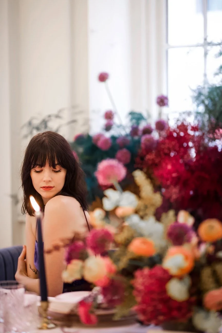 Low, colorful, modern floral centerpiece with ranunculus, sweet peas, acacia, and allium. Tennessee wedding florist.