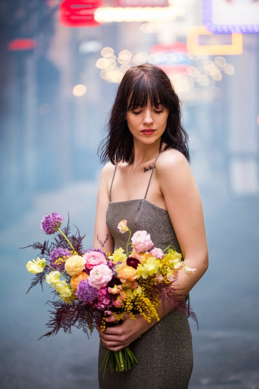 Modern, colorful bridal bouquet with yellow sweet peas, purple allium, pink and peach ranunculus, golden acacia, and painted eggplant plums fern. Nashville wedding florist. Printer’s Alley portraits.