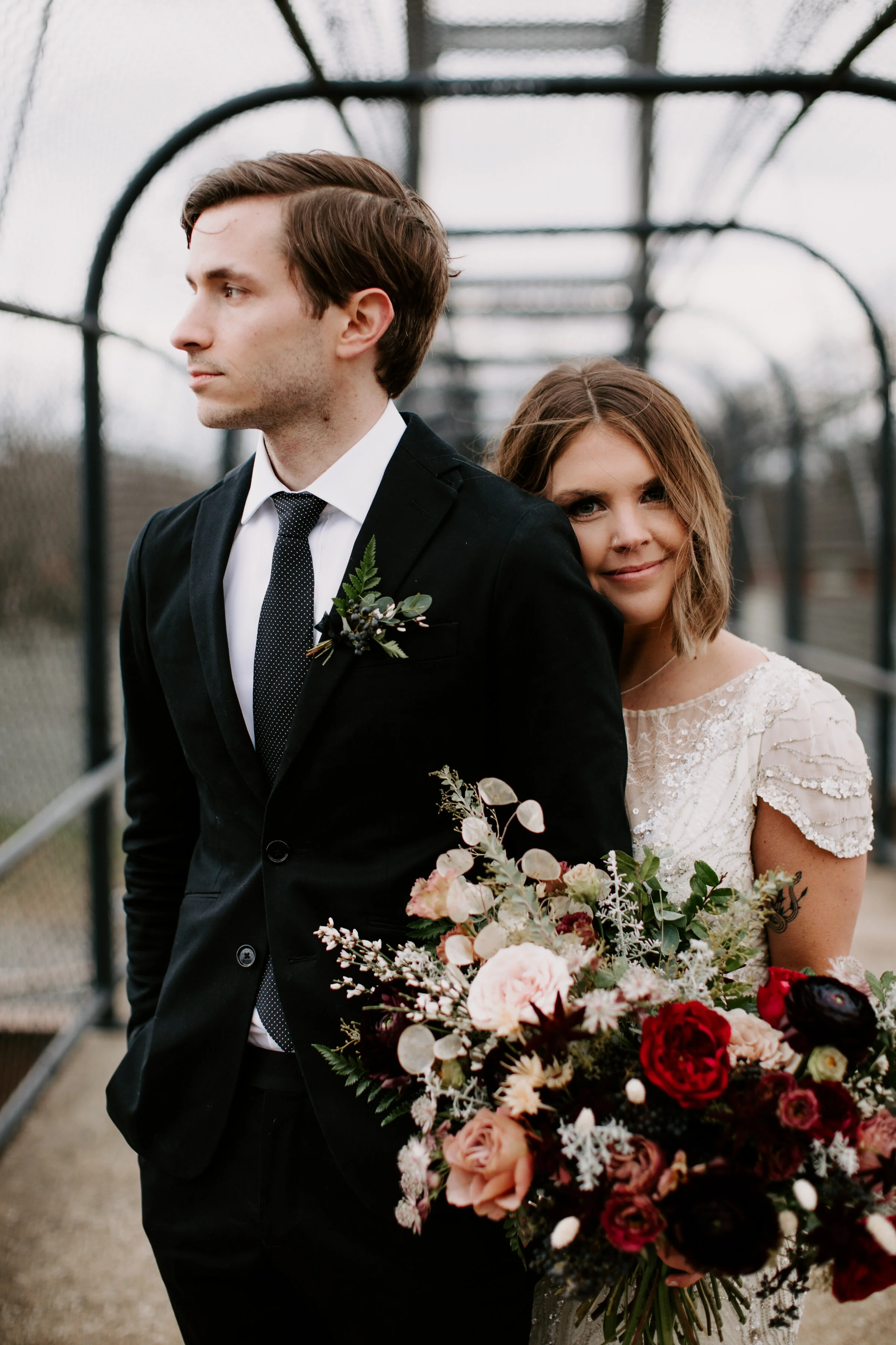 Loose, whimsical winter bridal bouquet with eggplant, blush, mauve, and burgundy garden roses and ranunculus, dried flowers, and natural, untamed greenery. Nashville wedding floral design at the Cordelle.