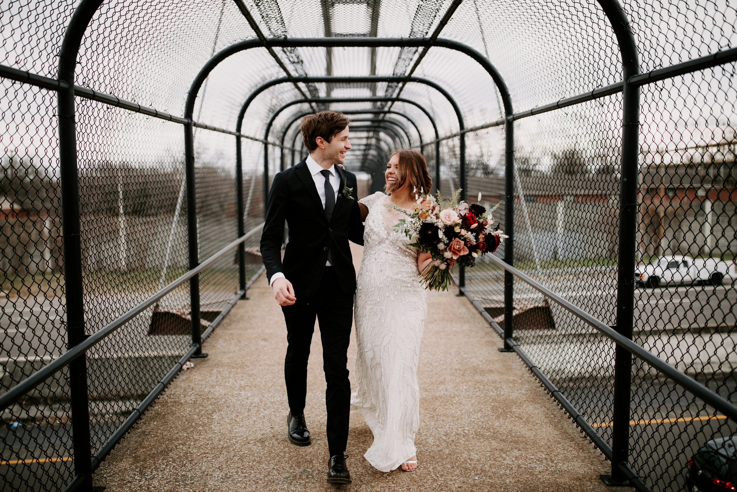 Loose, whimsical winter bridal bouquet with eggplant, blush, mauve, and burgundy garden roses and ranunculus, dried flowers, and natural, untamed greenery. Nashville wedding floral design at the Cordelle.