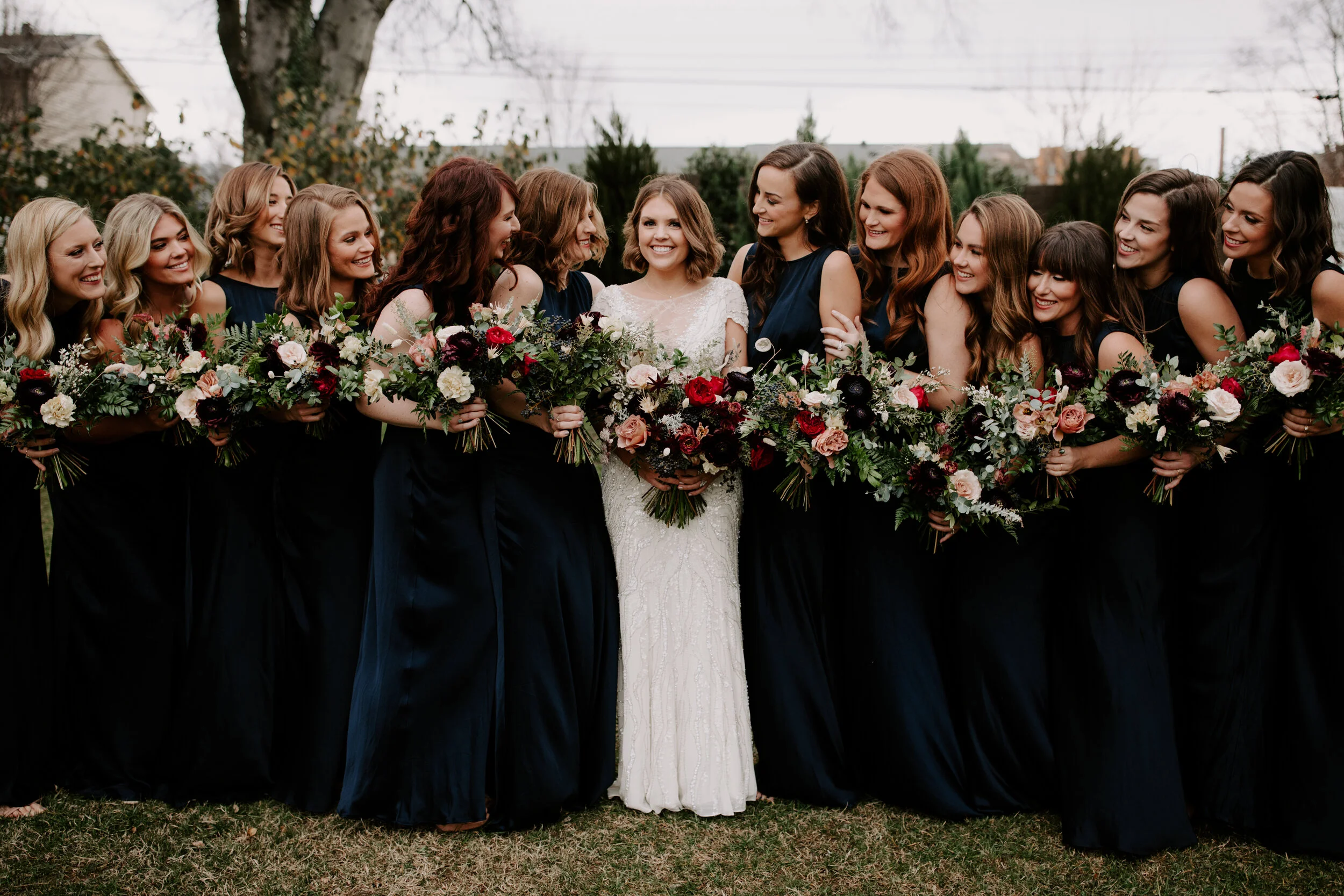 Navy silk bridesmaid dresses with jewel tone flowers with airy, natural greenery. Nashville wedding florist at the Cordelle.