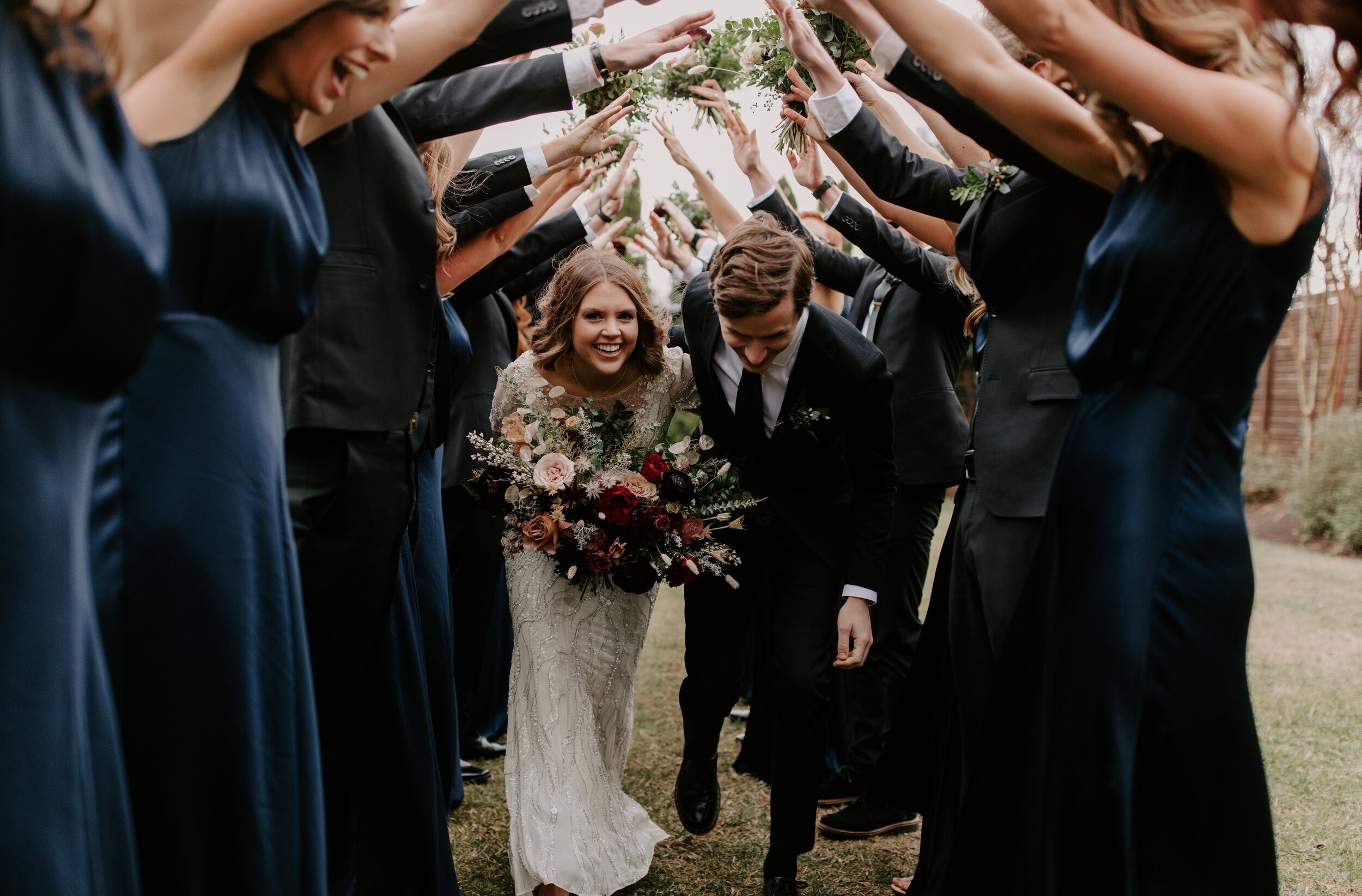 Navy silk bridesmaid dresses with jewel tone flowers with airy, natural greenery. Nashville wedding florist at the Cordelle.