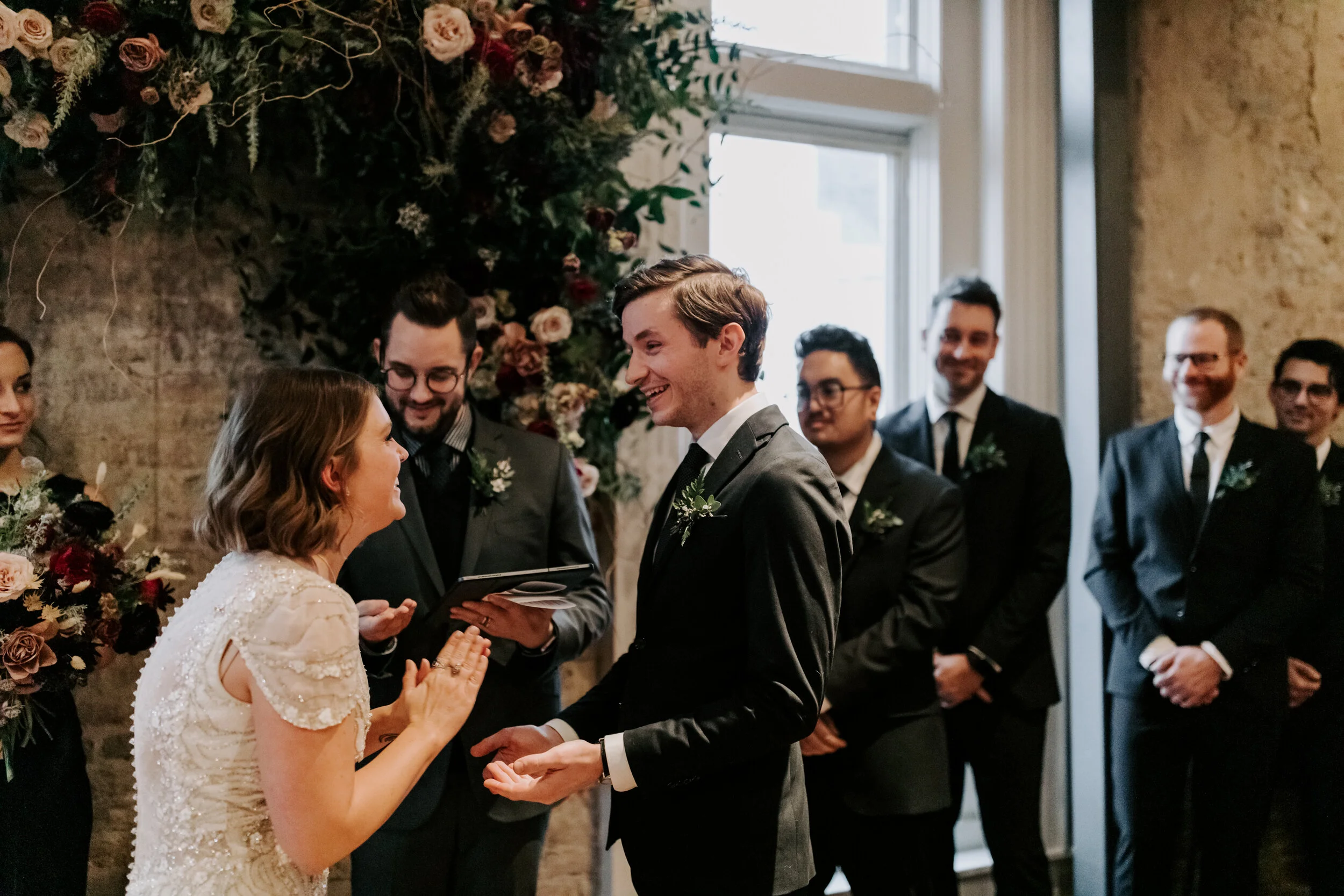Organic, hanging floral installation for the wedding ceremony backdrop with lush greenery, curly willow branches, and earth toned and burgundy flowers. Nashville wedding florist at the Cordelle.