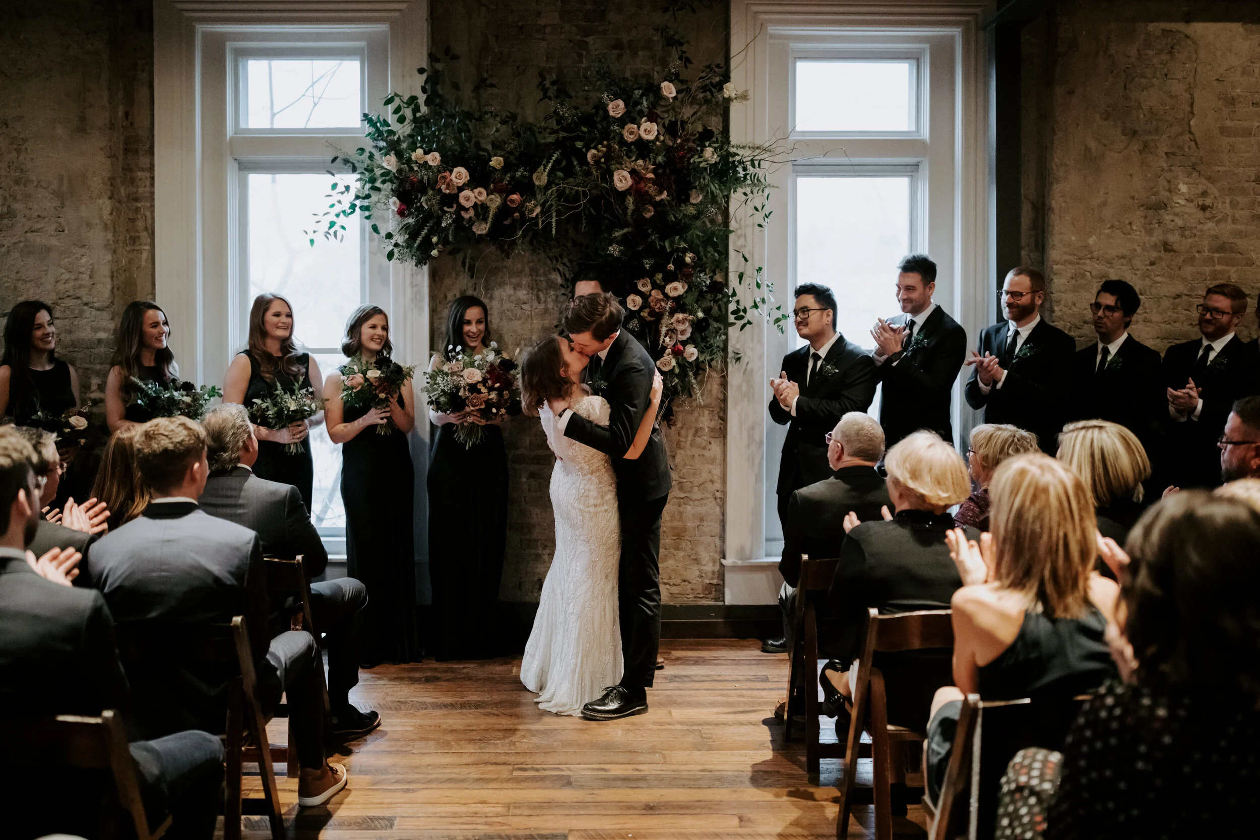 Organic, hanging floral installation for the wedding ceremony backdrop with lush greenery, curly willow branches, and earth toned and burgundy flowers. Nashville wedding florist at the Cordelle.