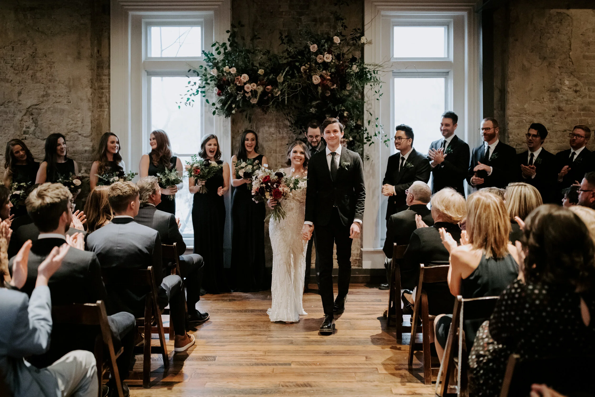 Organic, hanging floral installation for the wedding ceremony backdrop with lush greenery, curly willow branches, and earth toned and burgundy flowers. Nashville wedding florist at the Cordelle.