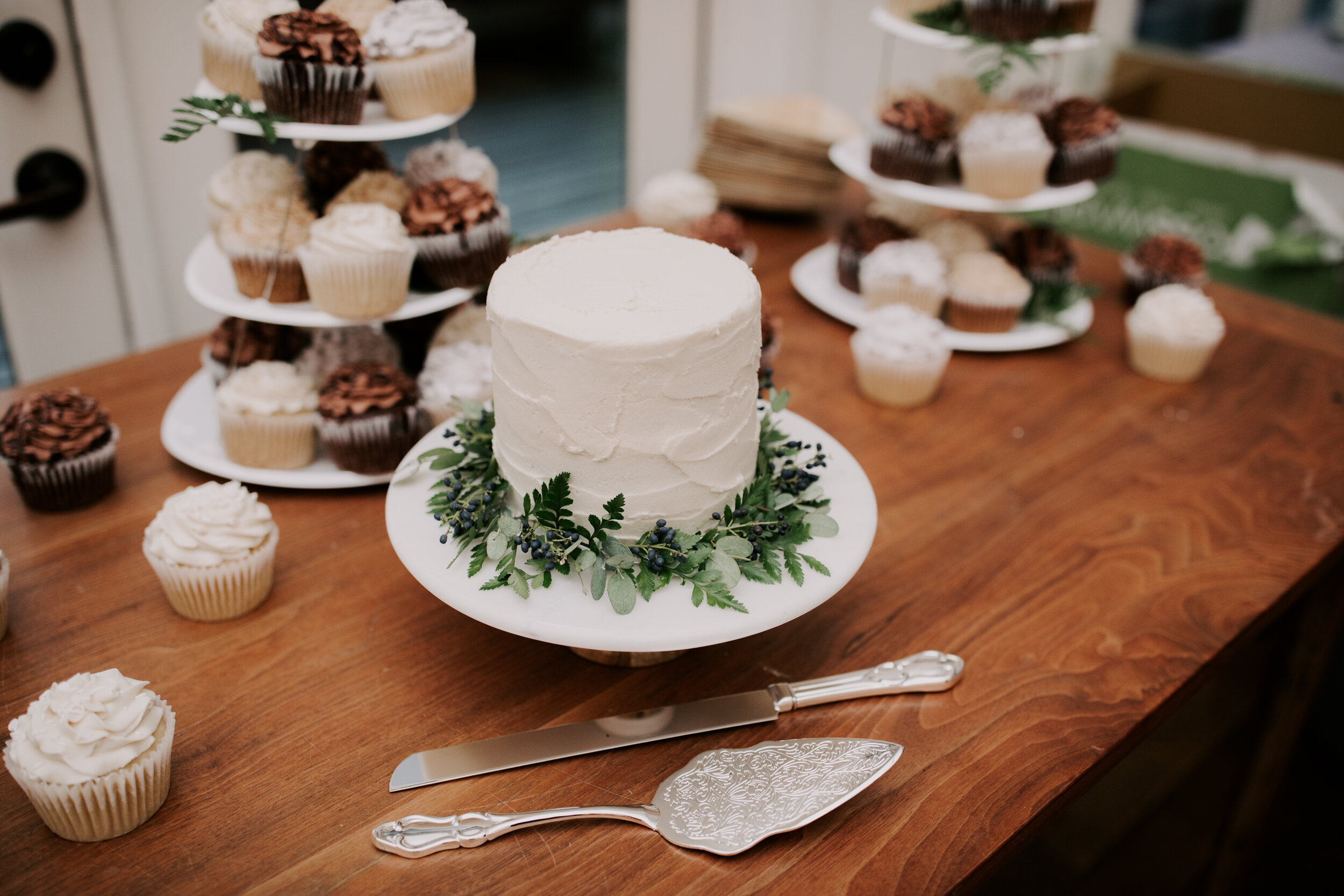 Simple cake with greenery wreath. Nashville wedding florist.