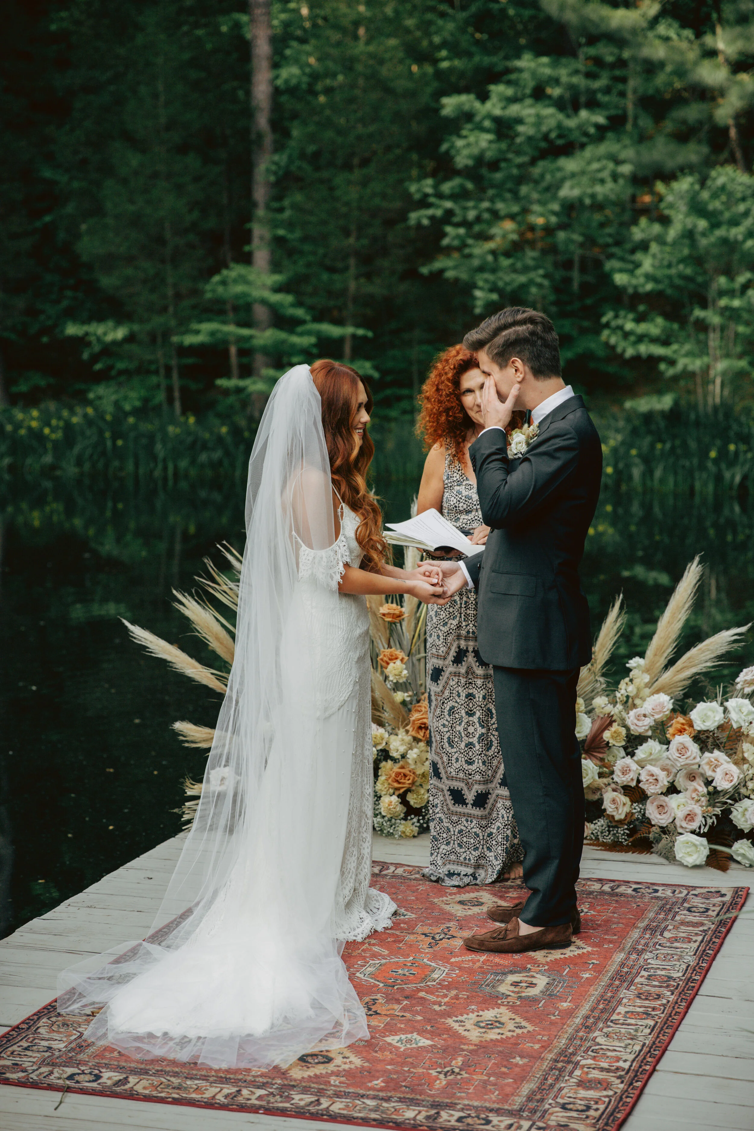 Bohemian, modern floral installation with gold and blush roses, pampas grass, dried ferns, and dried palms, growing on a private dock with a Turkish rug. Nashville wedding florist.