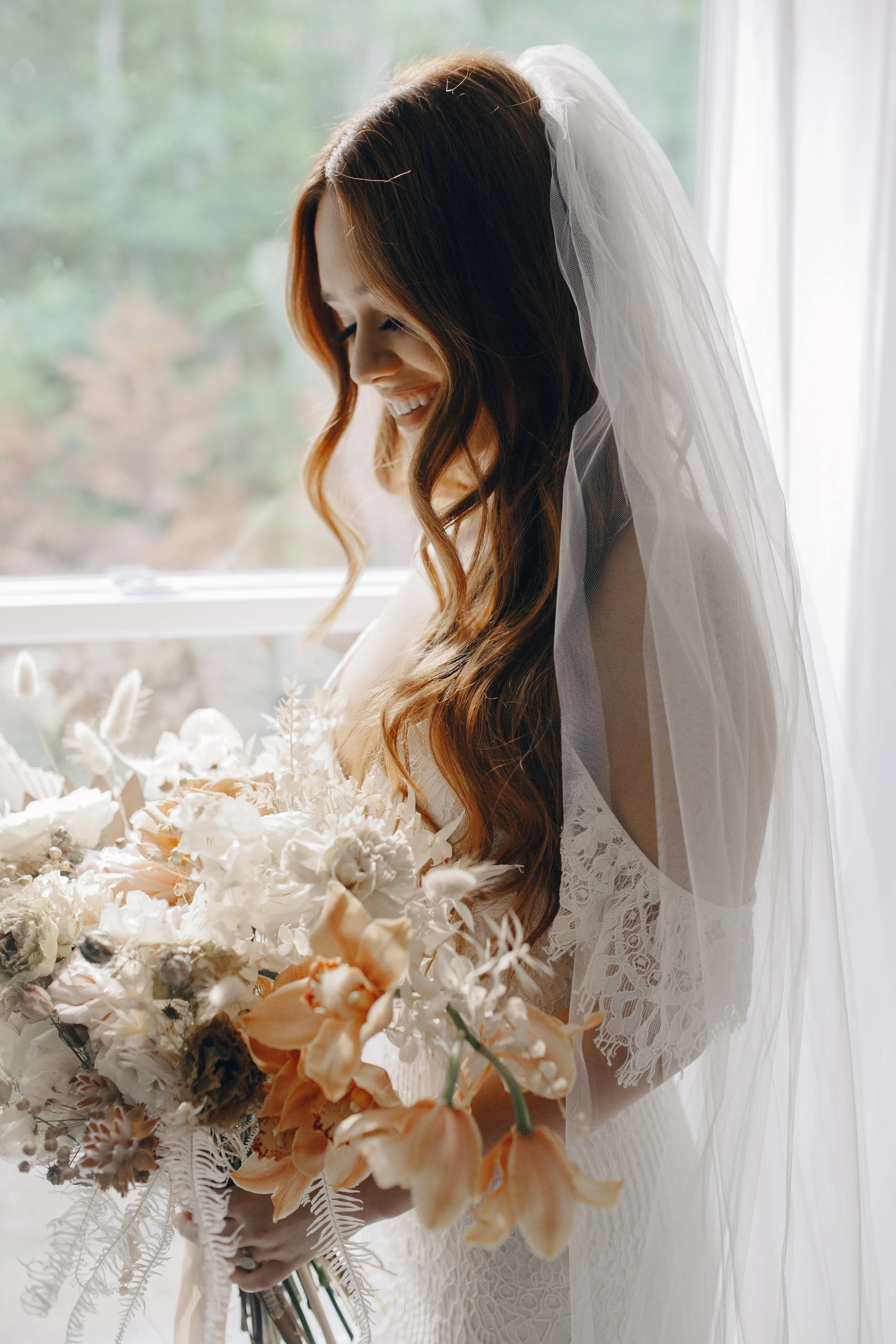 Lush, bohemian bridal bouquet with white garden roses, copper orchids, dried white ferns, earthy textures, and toffee lisianthus. Nashville wedding and elopement floral designer.