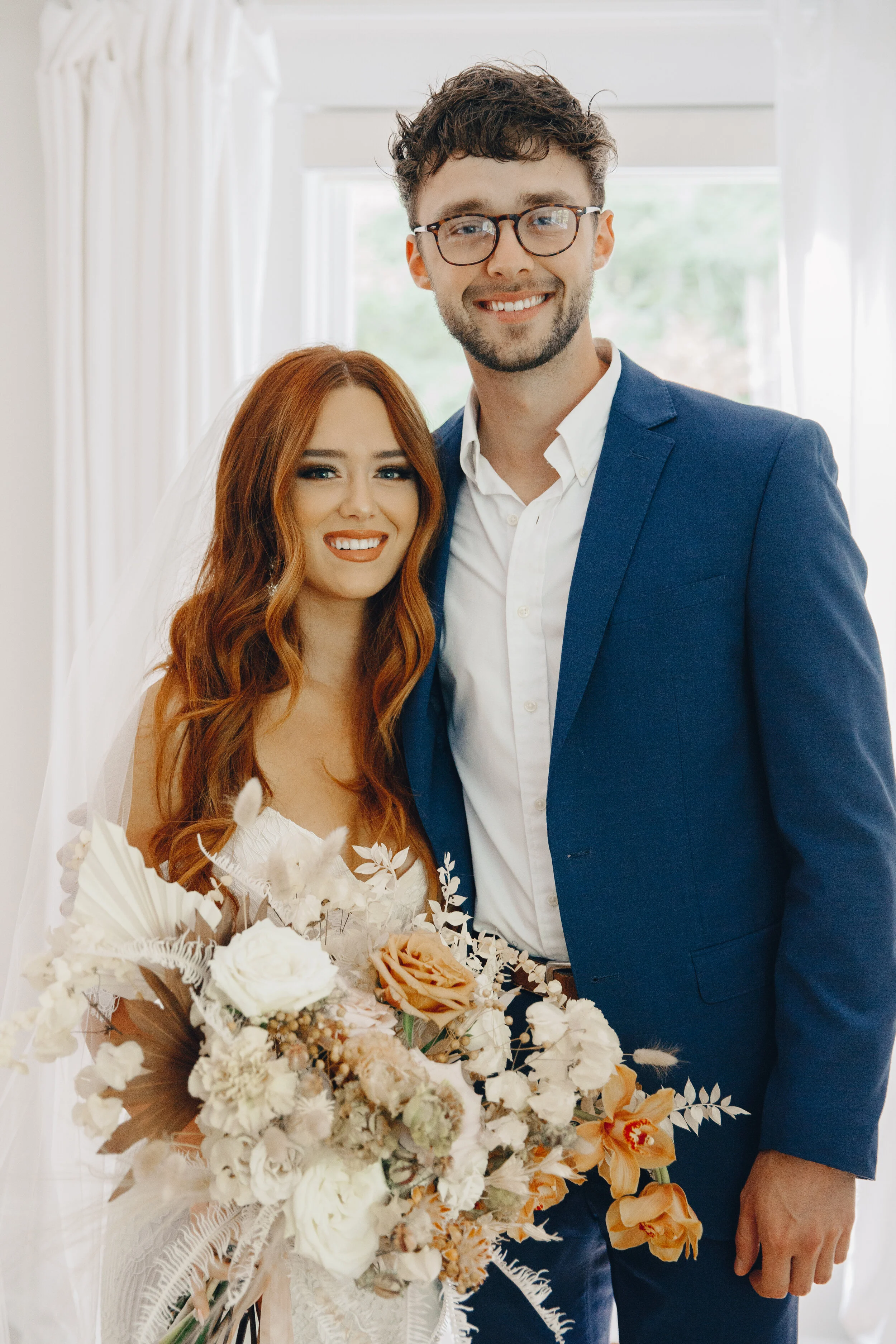 Lush, bohemian bridal bouquet with white garden roses, copper orchids, dried white ferns, earthy textures, and toffee lisianthus. Nashville wedding and elopement floral designer.