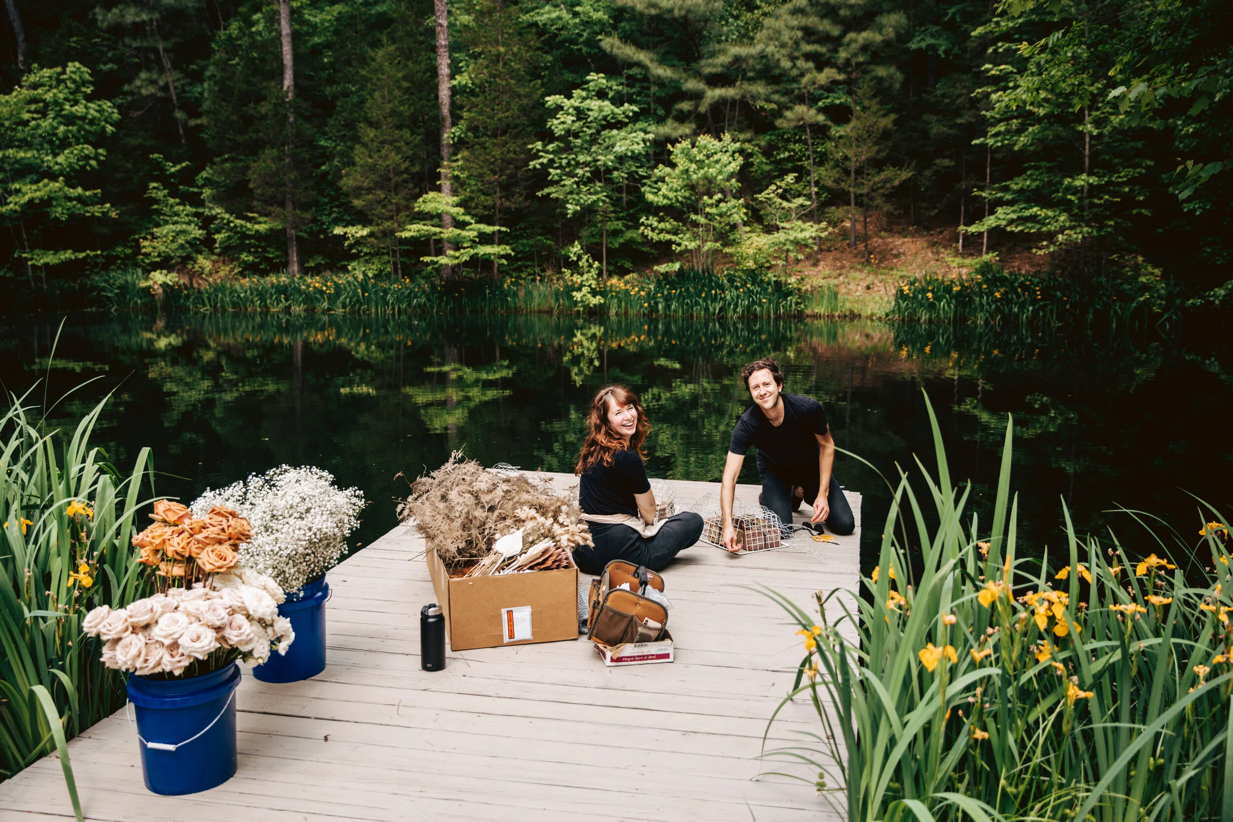 Bohemian, modern floral installation with gold and blush roses, pampas grass, dried ferns, and dried palms, growing on a private dock with a Turkish rug. Nashville wedding florist.