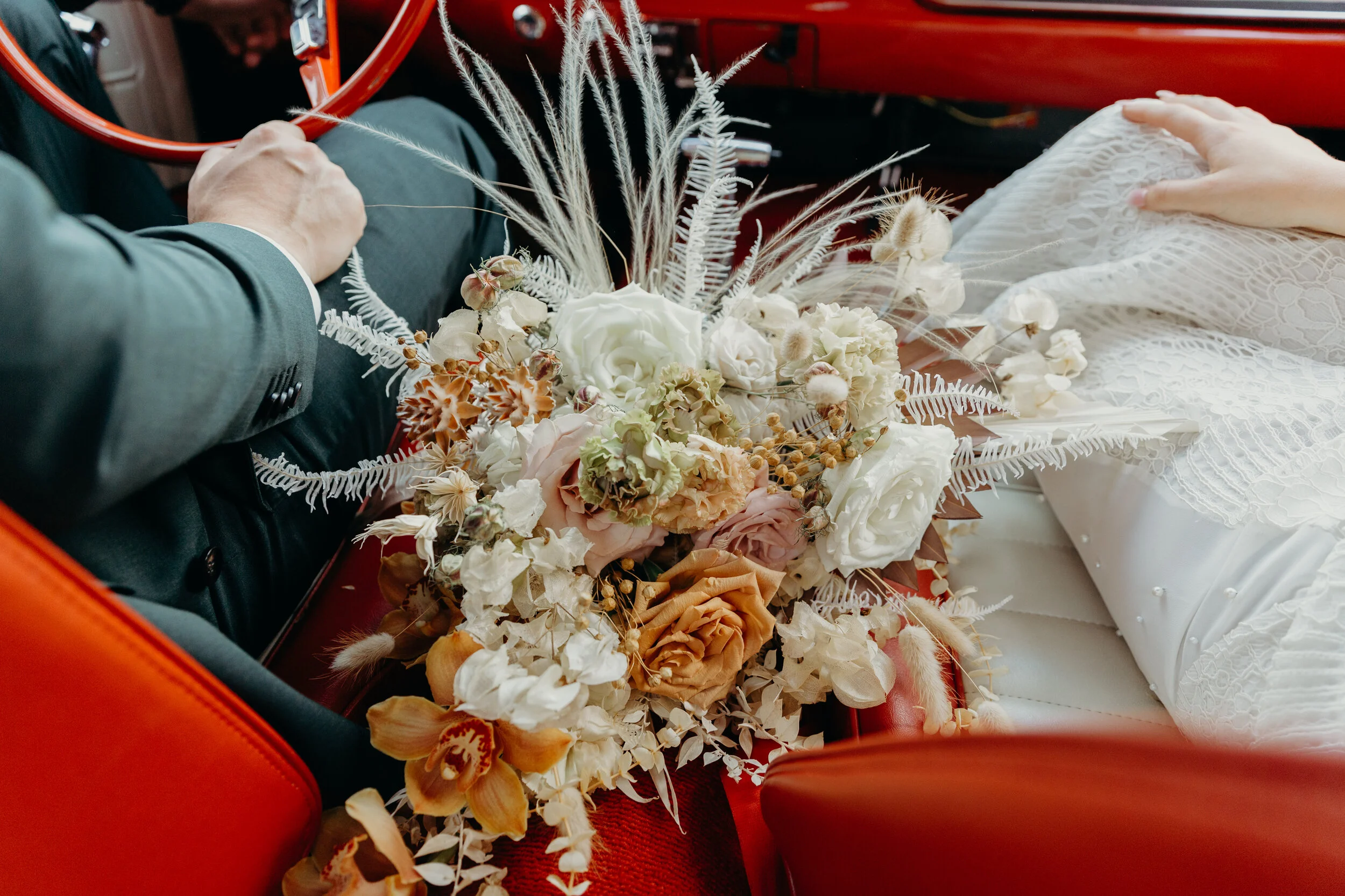 Lush, bohemian bridal bouquet with white garden roses, copper orchids, dried white ferns, earthy textures, and toffee lisianthus. Nashville wedding and elopement floral designer.