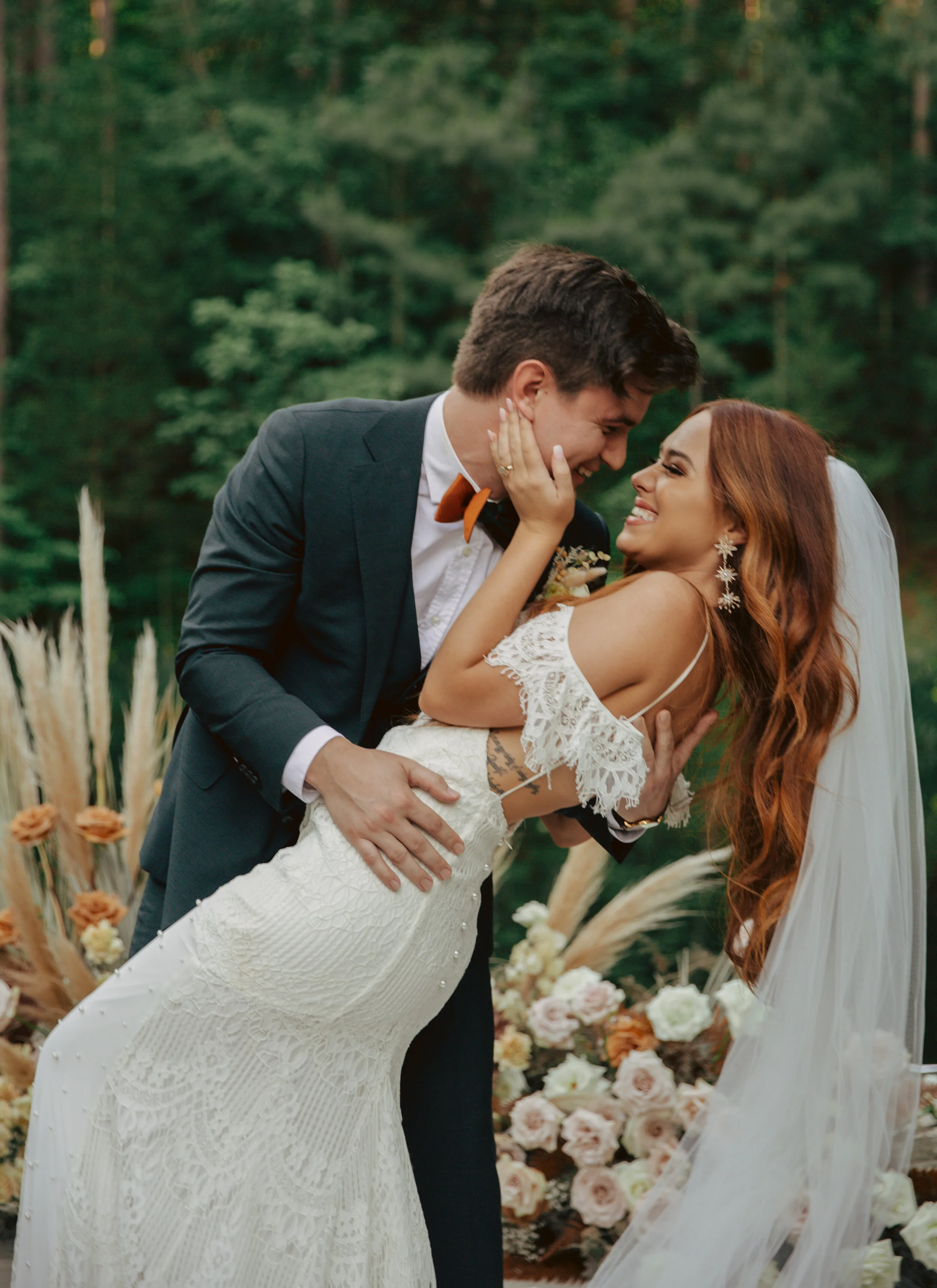 Bohemian, modern floral installation with gold and blush roses, pampas grass, dried ferns, and dried palms, growing on a private dock with a Turkish rug. Nashville wedding florist.