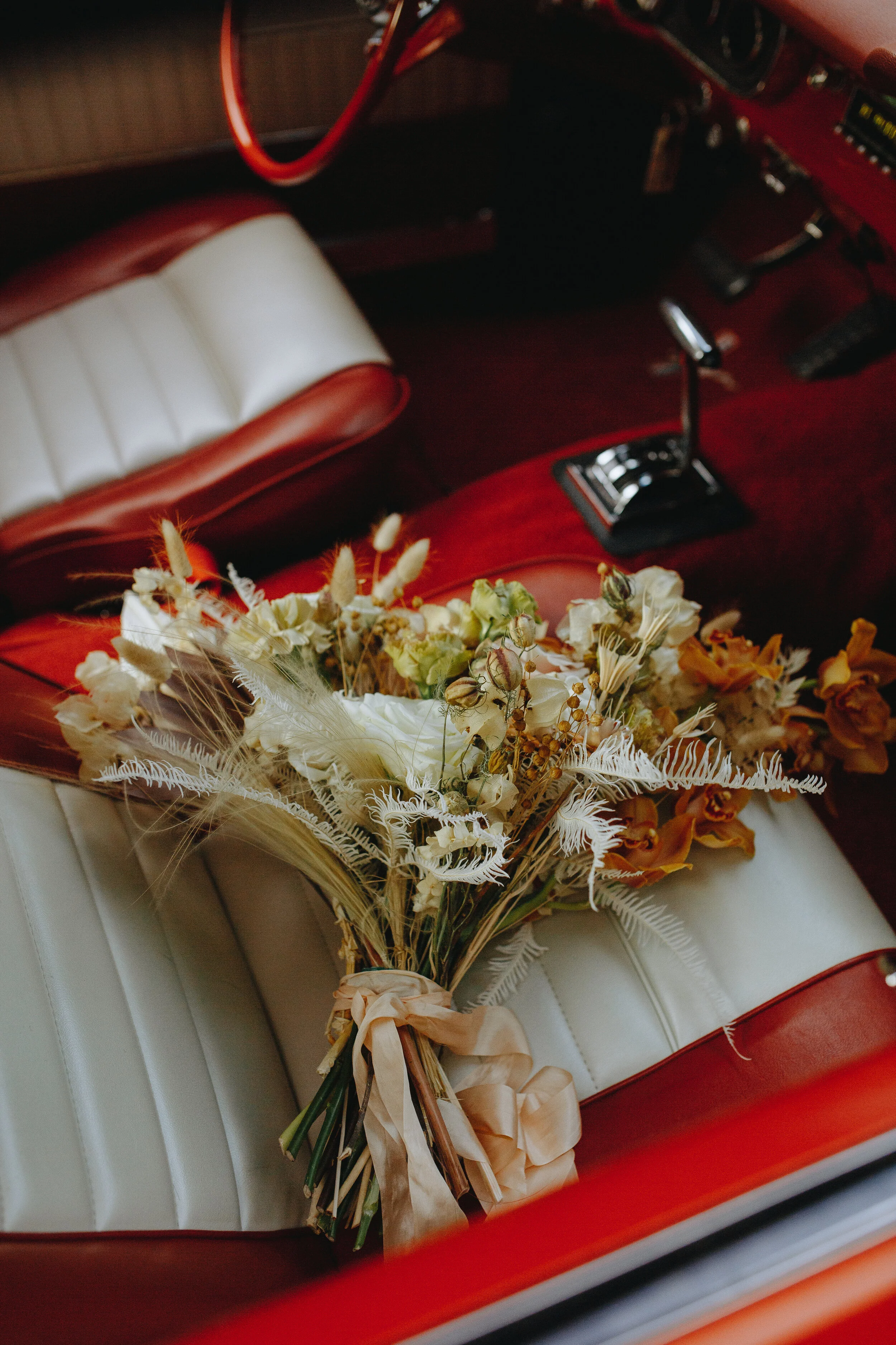 Lush, bohemian bridal bouquet with white garden roses, copper orchids, dried white ferns, earthy textures, and toffee lisianthus. Nashville wedding and elopement floral designer.