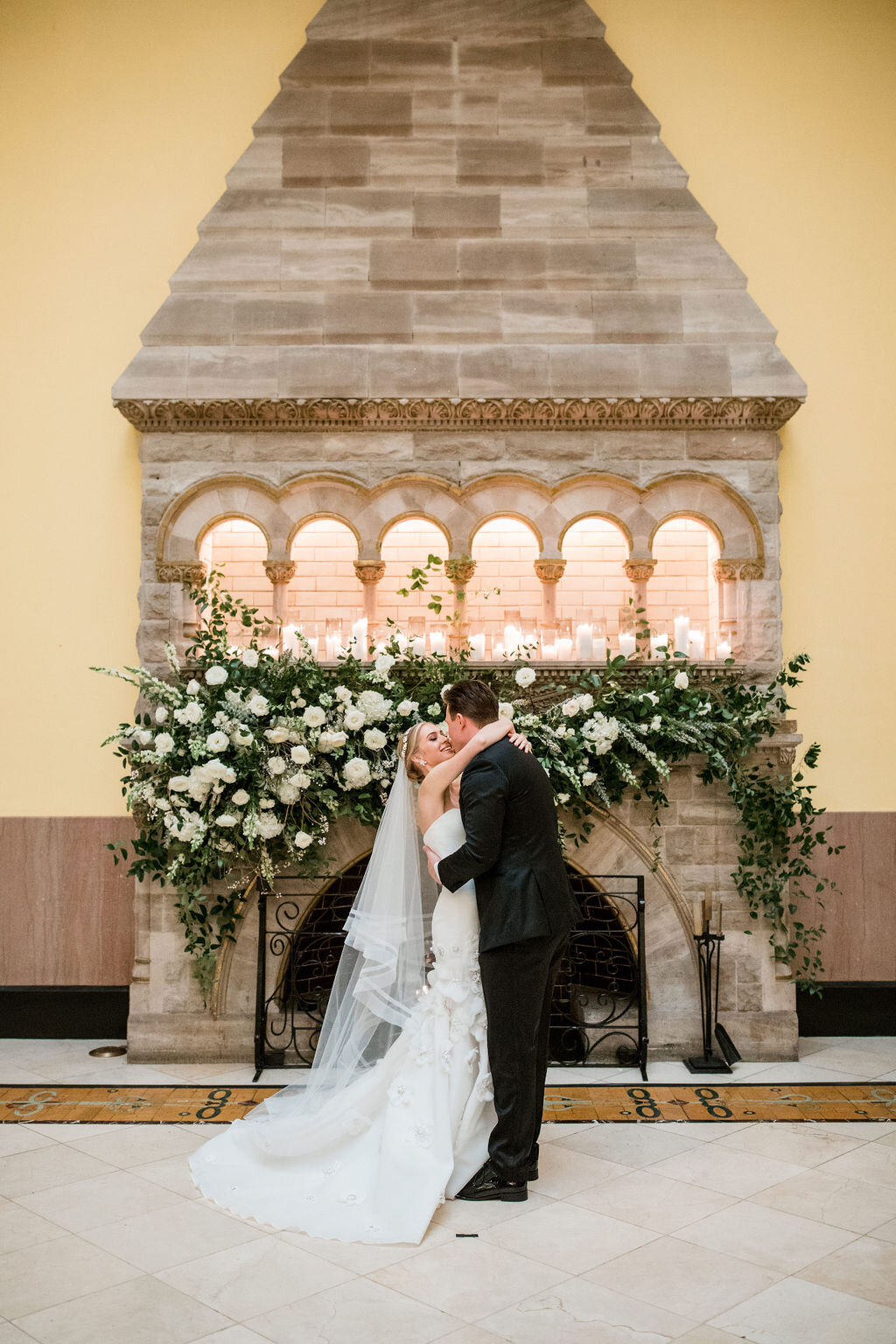Lush fireplace mantle floral installation with all white garden roses and ranunculus with natural, untamed greenery and eucalyptus. Nashville floral designer, Rosemary & Finch, for a wedding at Union Station.
