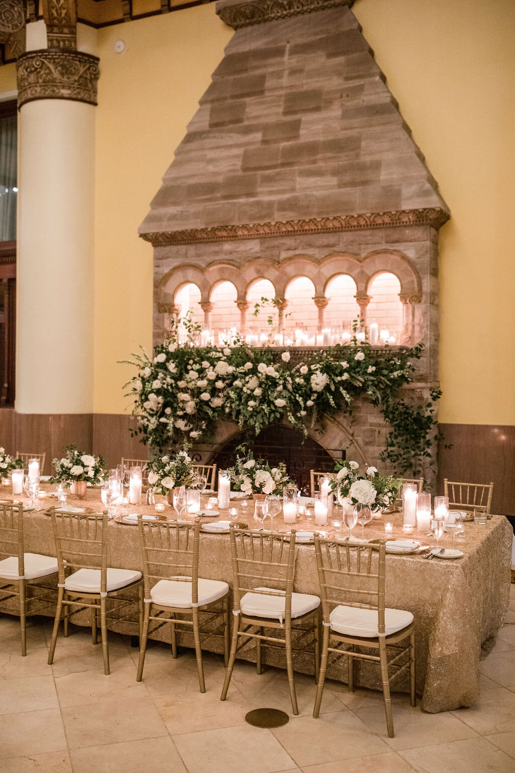 Lush fireplace mantle floral installation with all white garden roses, hydrangeas, and ranunculus with natural, untamed greenery and eucalyptus. Head table backdrop. Nashville floral designer, Rosemary & Finch, for a wedding at Union Station.