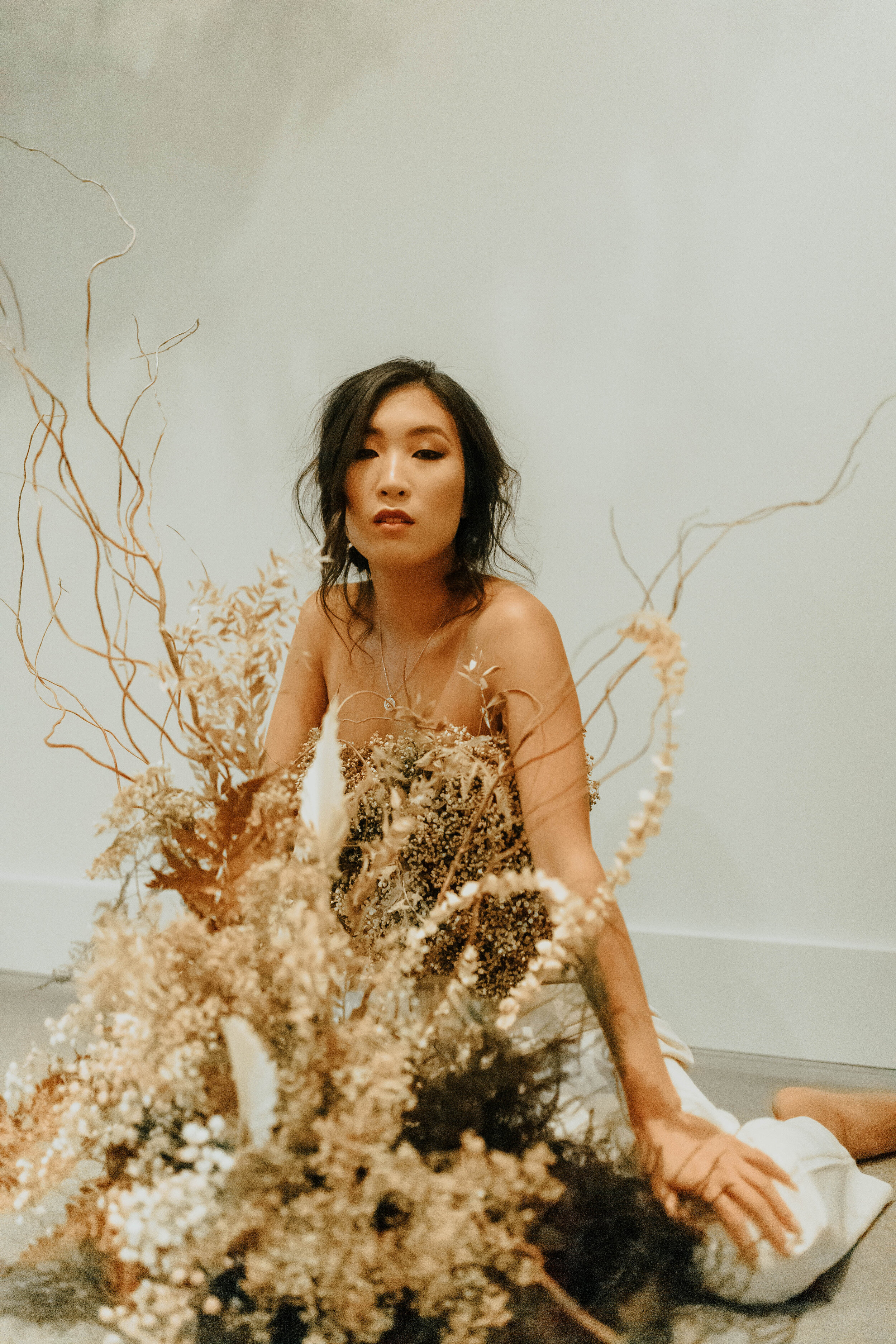 Earth tone floral design with shirt made of flowers - dyed baby’s breath. Nashville wedding florist at the Saint Elle.