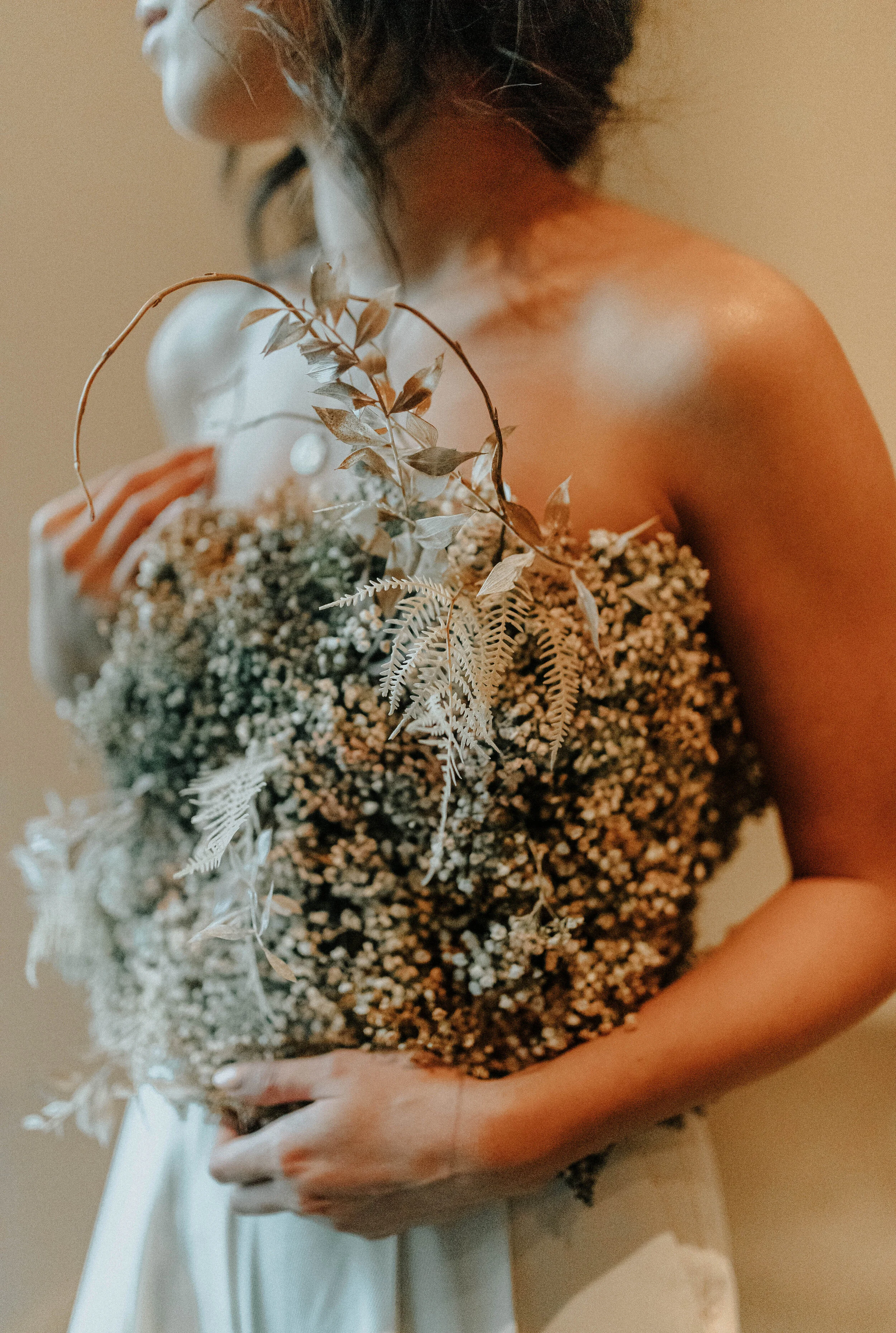 Earth tone floral design with shirt made of flowers - dyed baby’s breath. Nashville wedding florist at the Saint Elle.