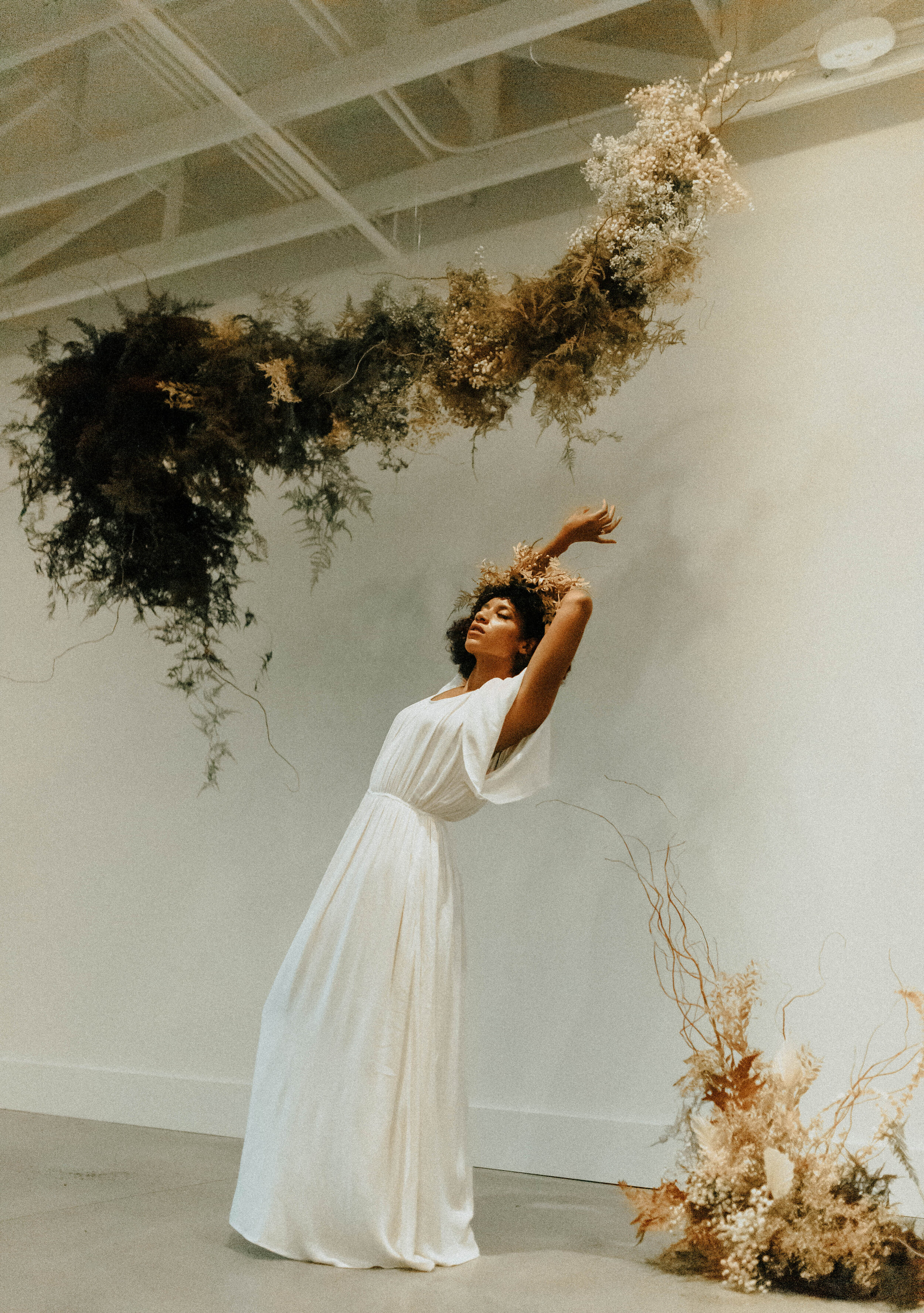 Skin tone inspired wearable floral design inspiration shoot. Earth tone hanging flower crown and floral installation at the Saint Elle, Nashville.