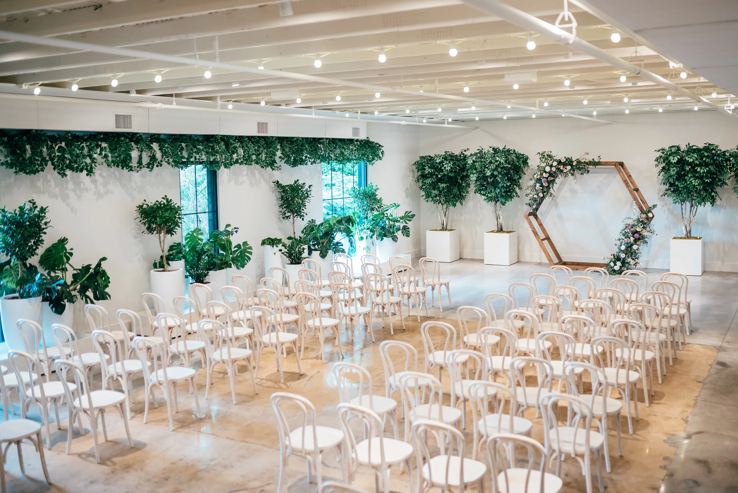 Hexagon floral arch in minimal venue with lots of plants. Lavender and mauve color palette, Nashville wedding floral design.