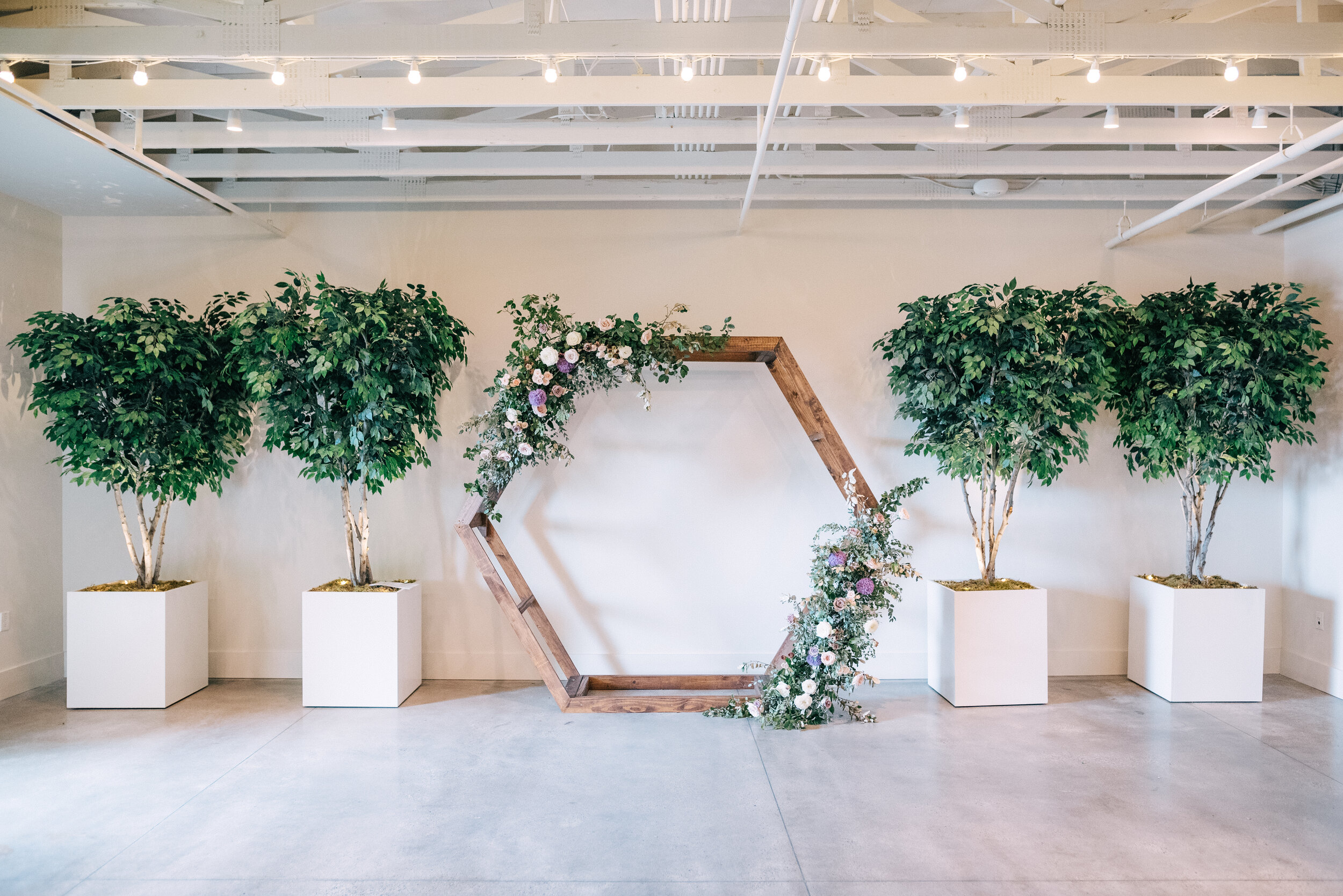 Hexagon floral arch in minimal venue with lots of plants. Lavender and mauve color palette, Nashville wedding floral design.
