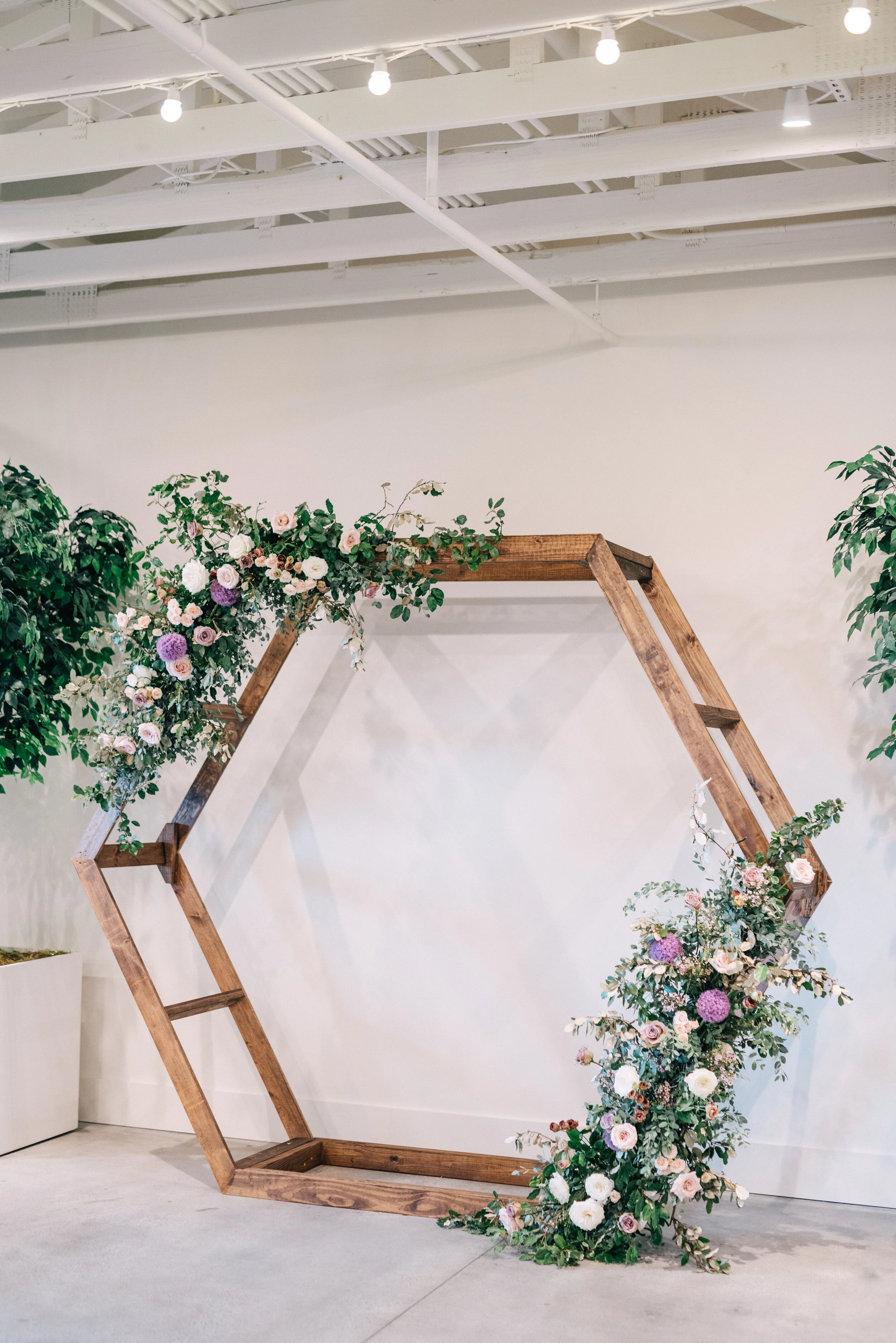 Hexagon floral arch in minimal venue with lots of plants. Lavender and mauve color palette, Nashville wedding floral design.