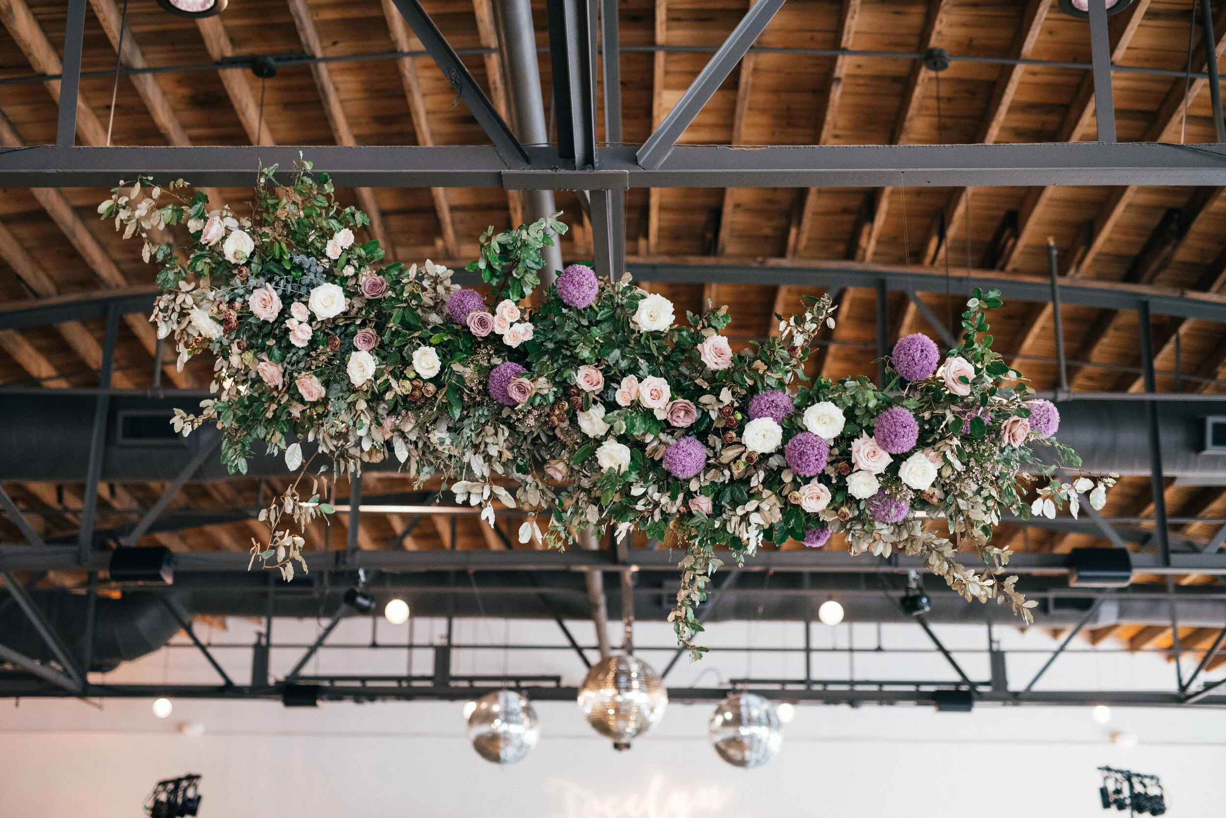Floating floral cloud installation with mauve garden roses, purple allium, blush spray roses, and lush, untamed greenery. Nashville wedding florist at the Saint Elle.