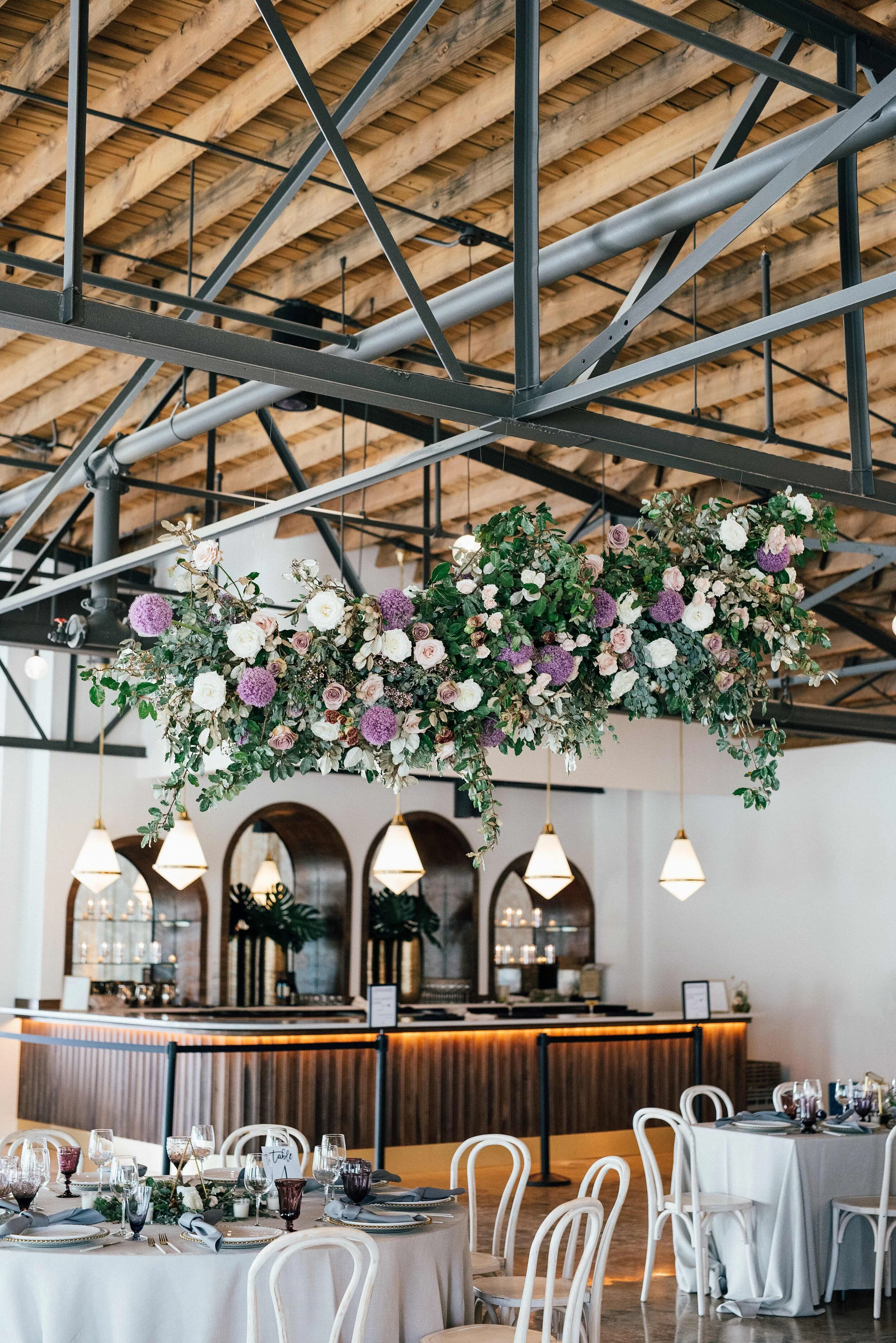 Floating floral cloud installation with mauve garden roses, purple allium, blush spray roses, and lush, untamed greenery. Nashville wedding florist at the Saint Elle.