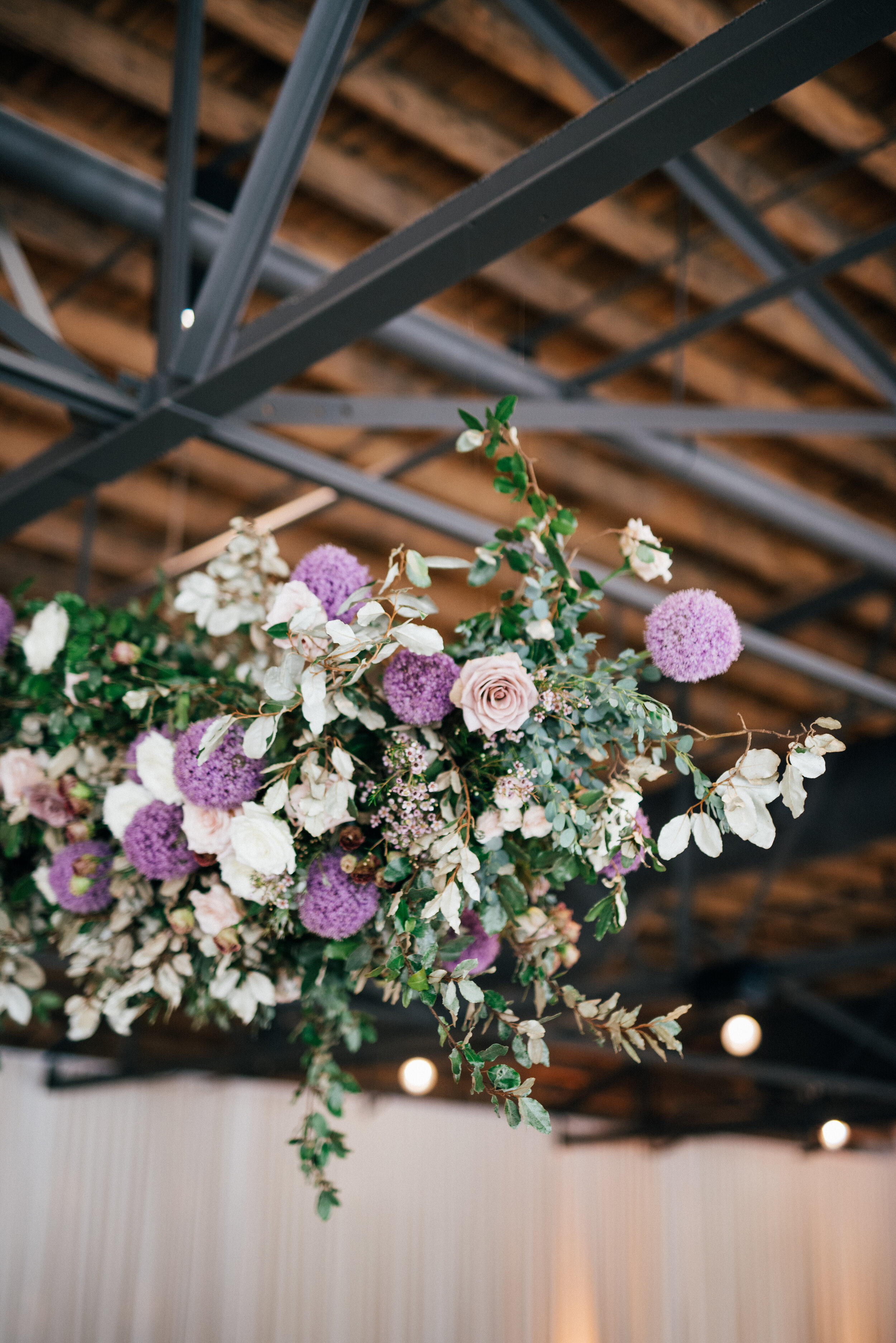 Floating floral cloud installation with mauve garden roses, purple allium, blush spray roses, and lush, untamed greenery. Nashville wedding florist at the Saint Elle.