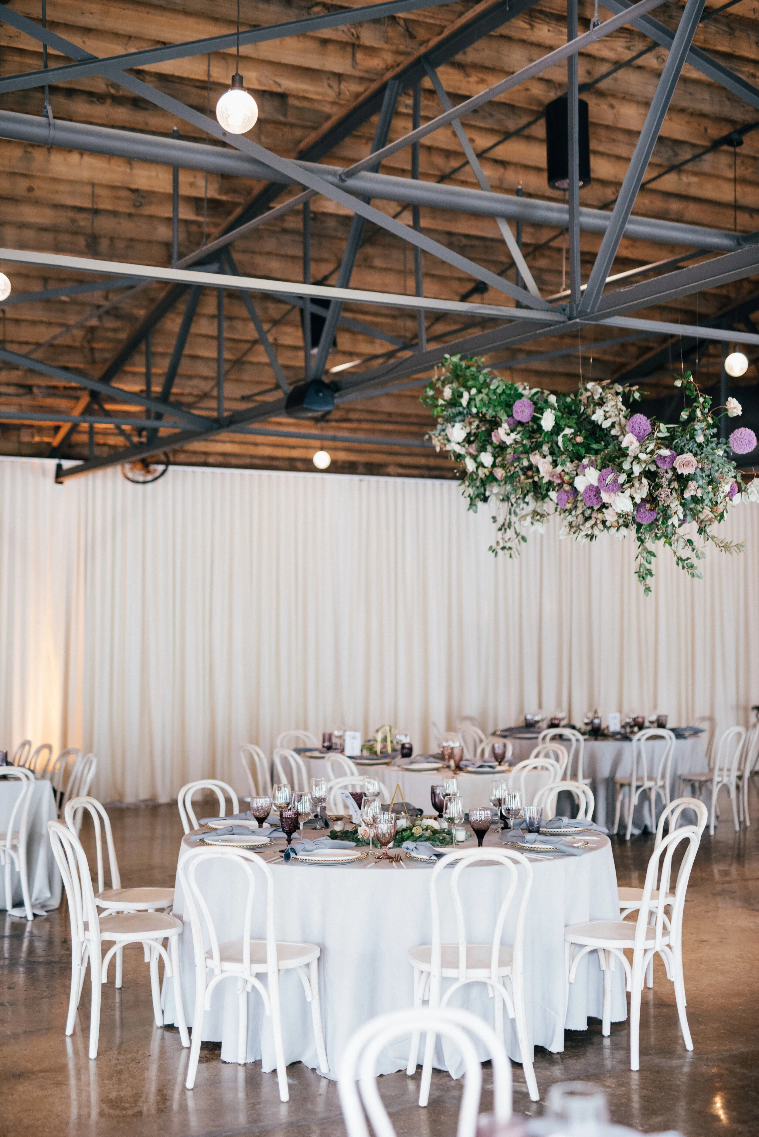 Floating floral cloud installation with mauve garden roses, purple allium, blush spray roses, and lush, untamed greenery. Nashville wedding florist at the Saint Elle.