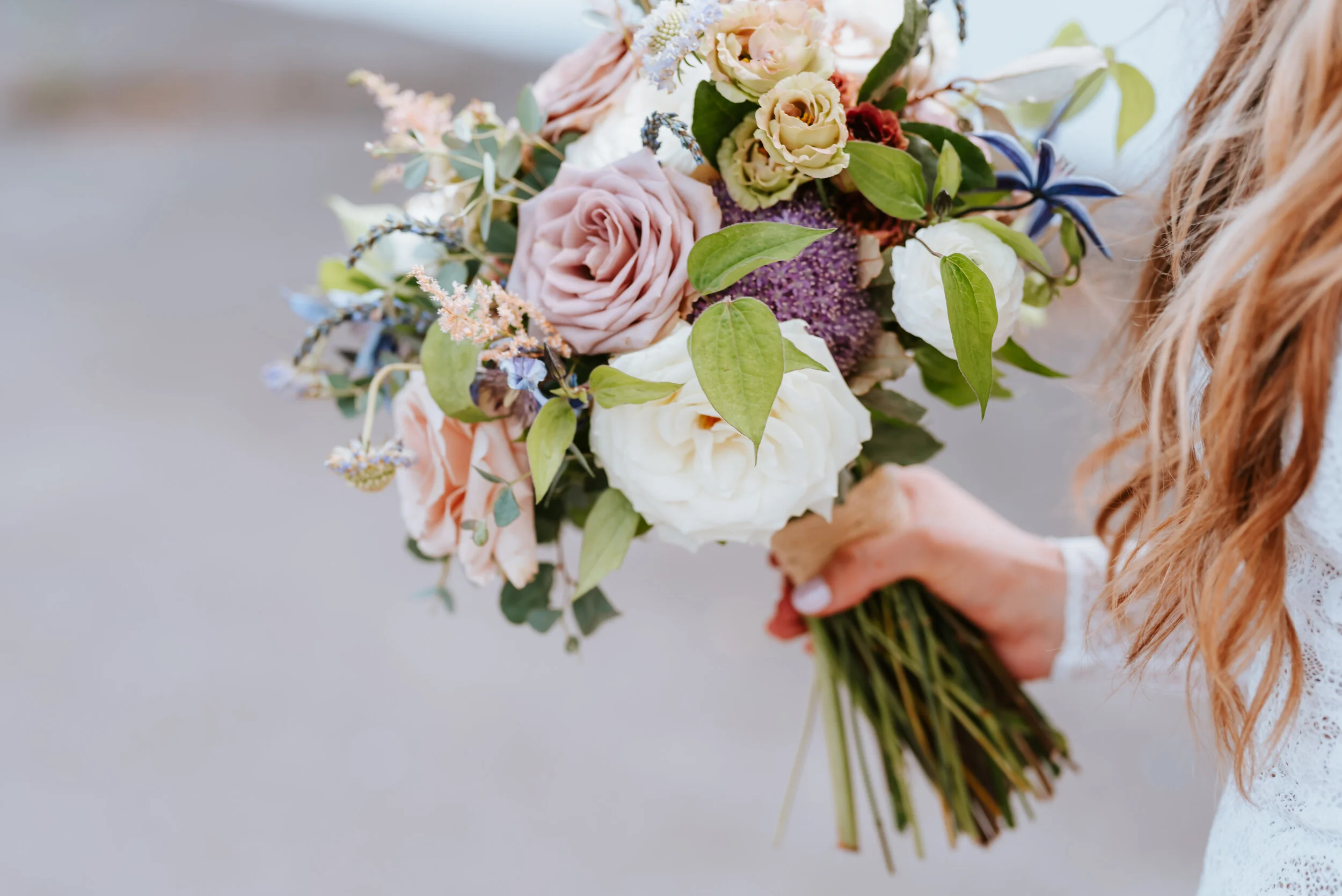 Lavender, mauve, and lilac bridal bouquet with garden roses, ranunculus, astilbe, scabies, clematis, eucalyptus, and greenery. Nashville wedding floral designer at the Saint Elle.