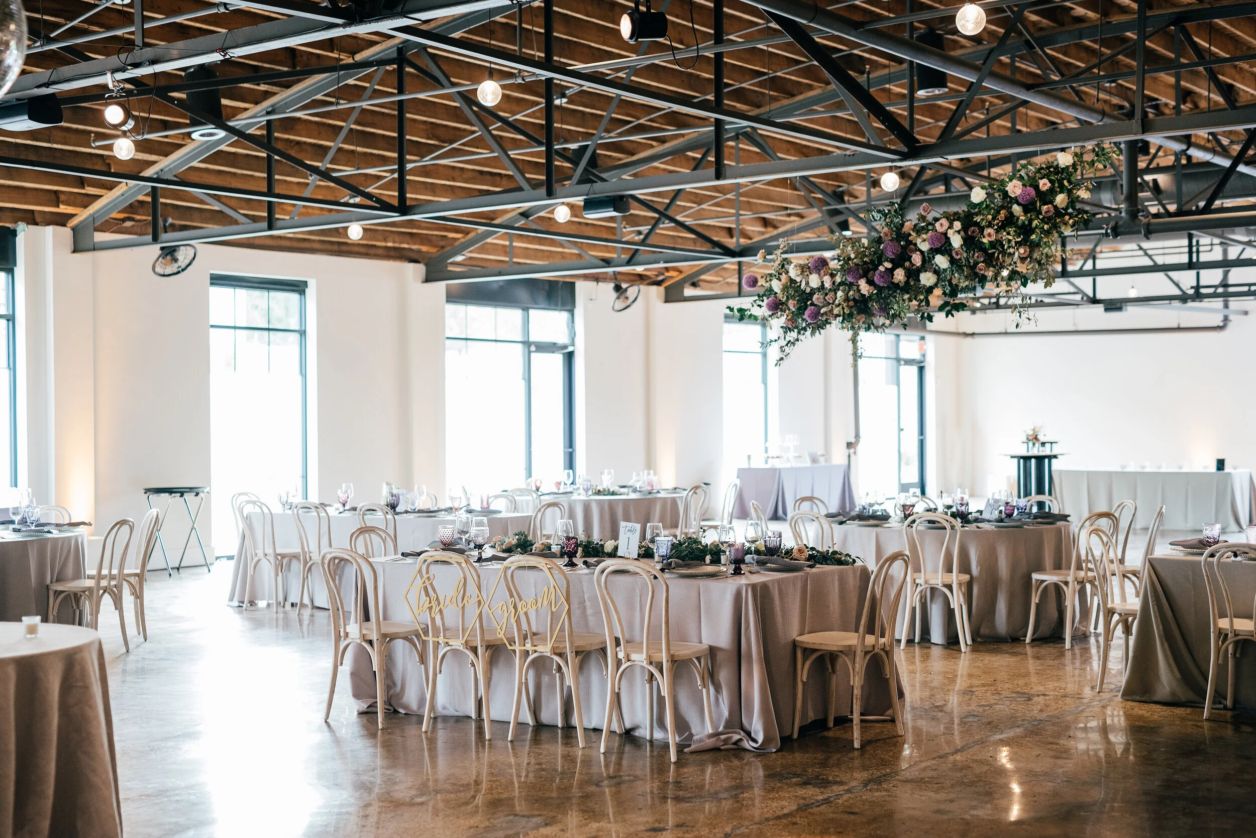 Floating floral cloud installation with mauve garden roses, purple allium, blush spray roses, and lush, untamed greenery. Nashville wedding florist at the Saint Elle.