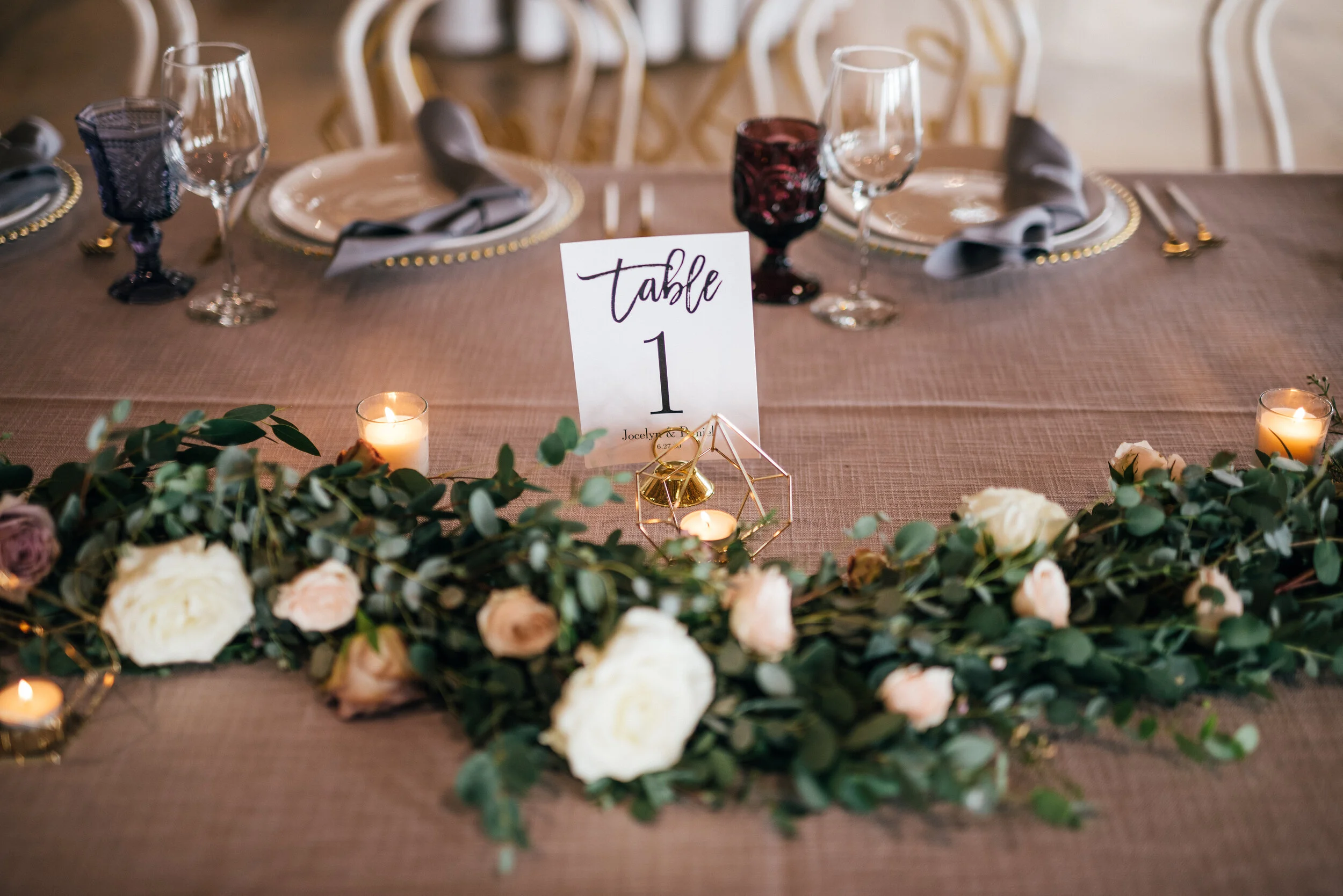 Head table garland runner of eucalyptus with blush and mauve floral accents. Nashville wedding florist.