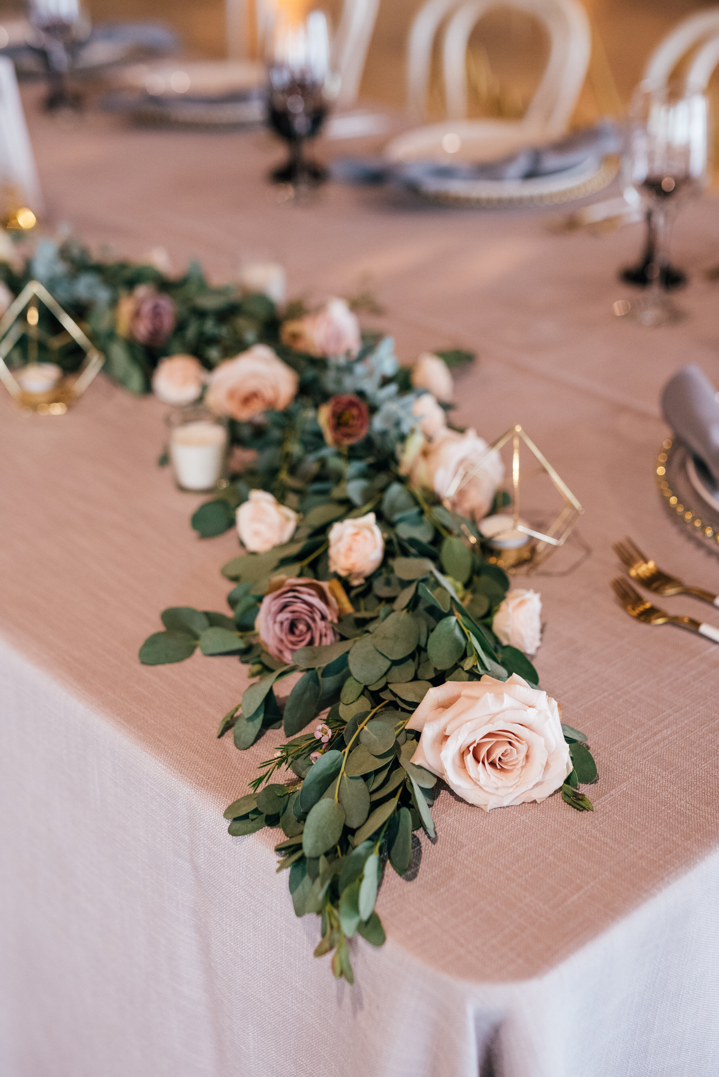 Head table garland runner of eucalyptus with blush and mauve floral accents. Nashville wedding florist.