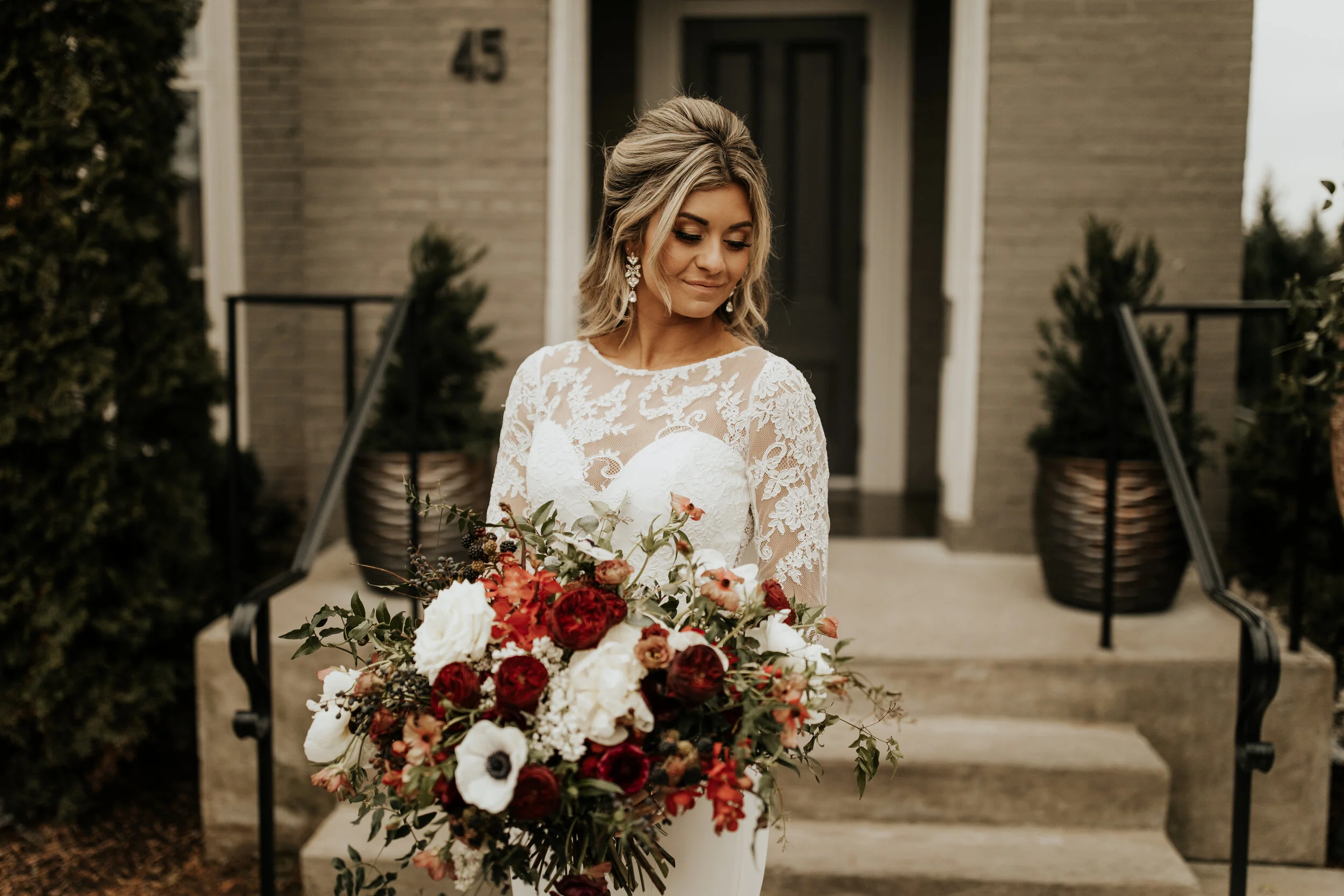 Lush, wintry bridal bouquet with anemones, white and burgundy peonies, ranunculus, garden roses, jasmine vine, and natural greenery. Nashville wedding floral designer, Rosemary & Finch.