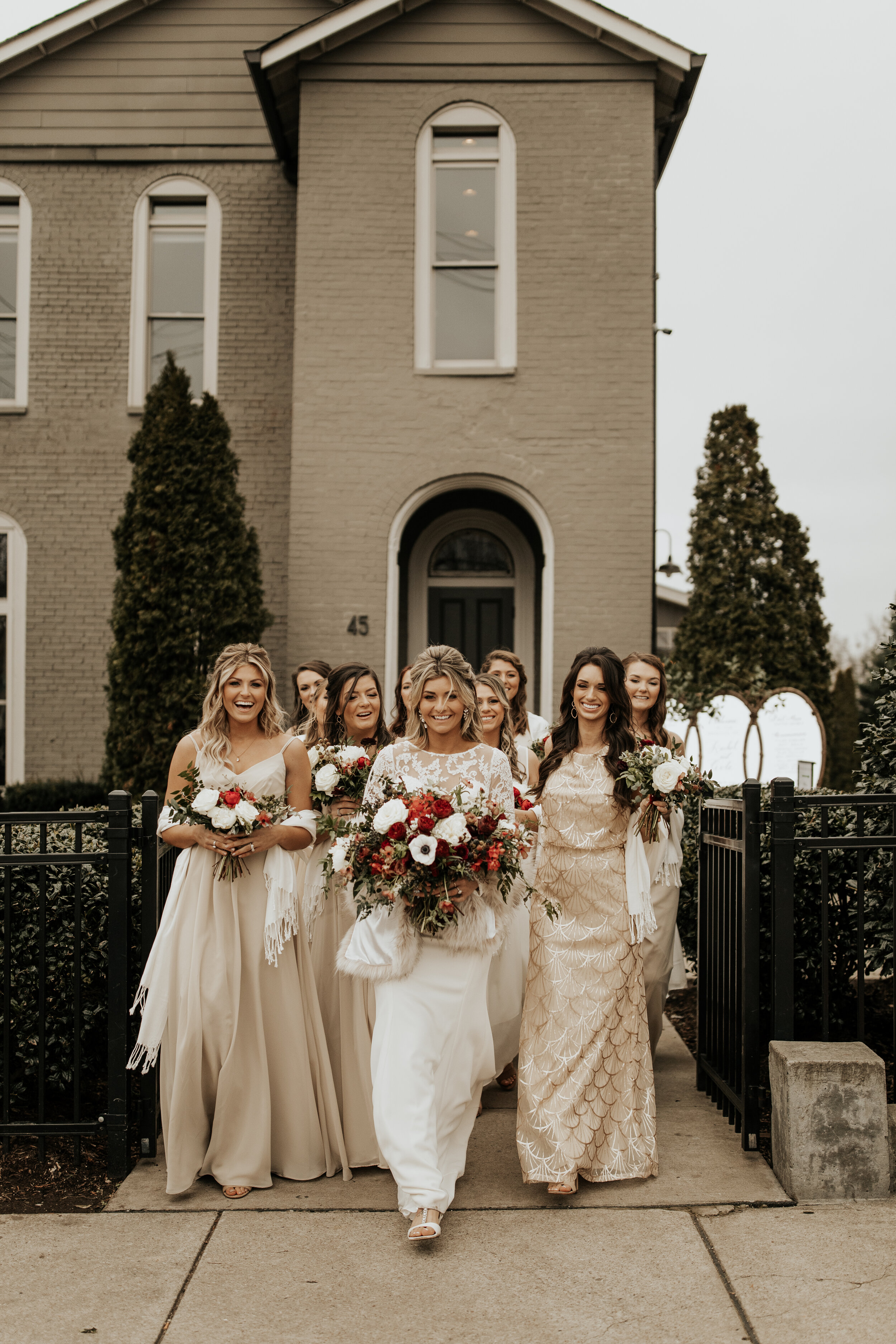 Neutral bridesmaid dresses with burgundy, white, and greenery bouquets of garden roses, peonies, and ranunculus for a wintry wedding at the Cordelle in Nashville.
