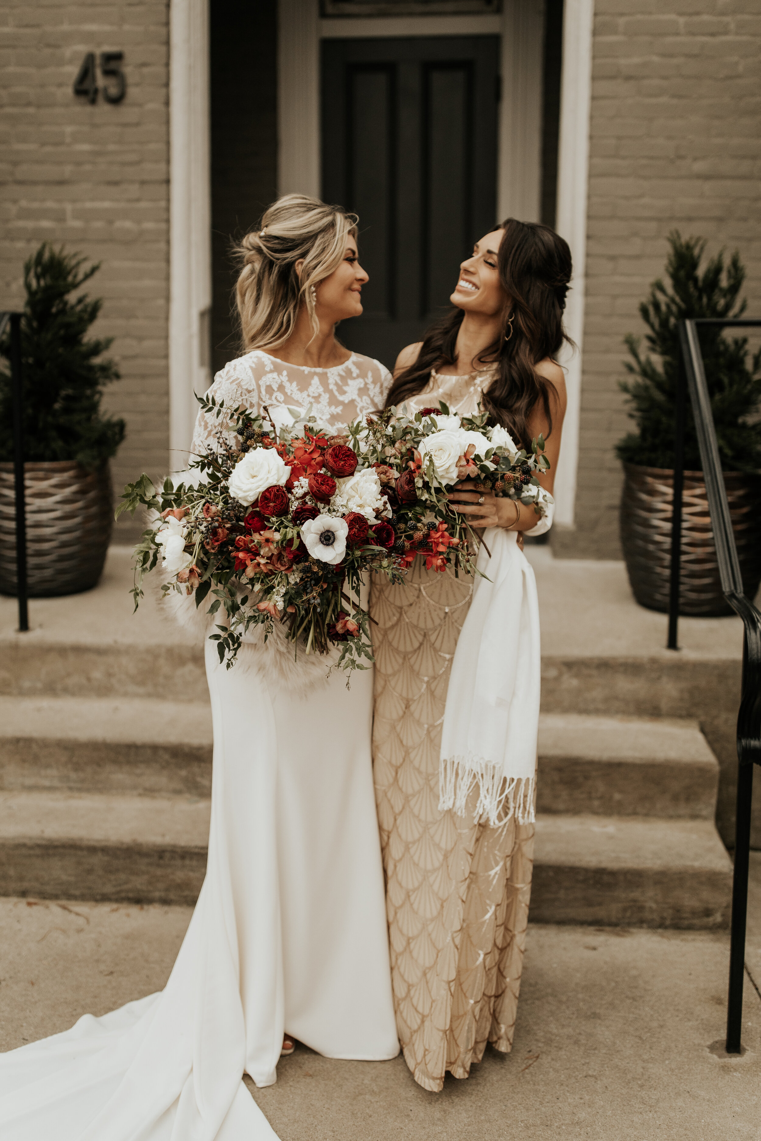 Neutral bridesmaid dresses with burgundy, white, and greenery bouquets of garden roses, peonies, and ranunculus for a wintry wedding at the Cordelle in Nashville.