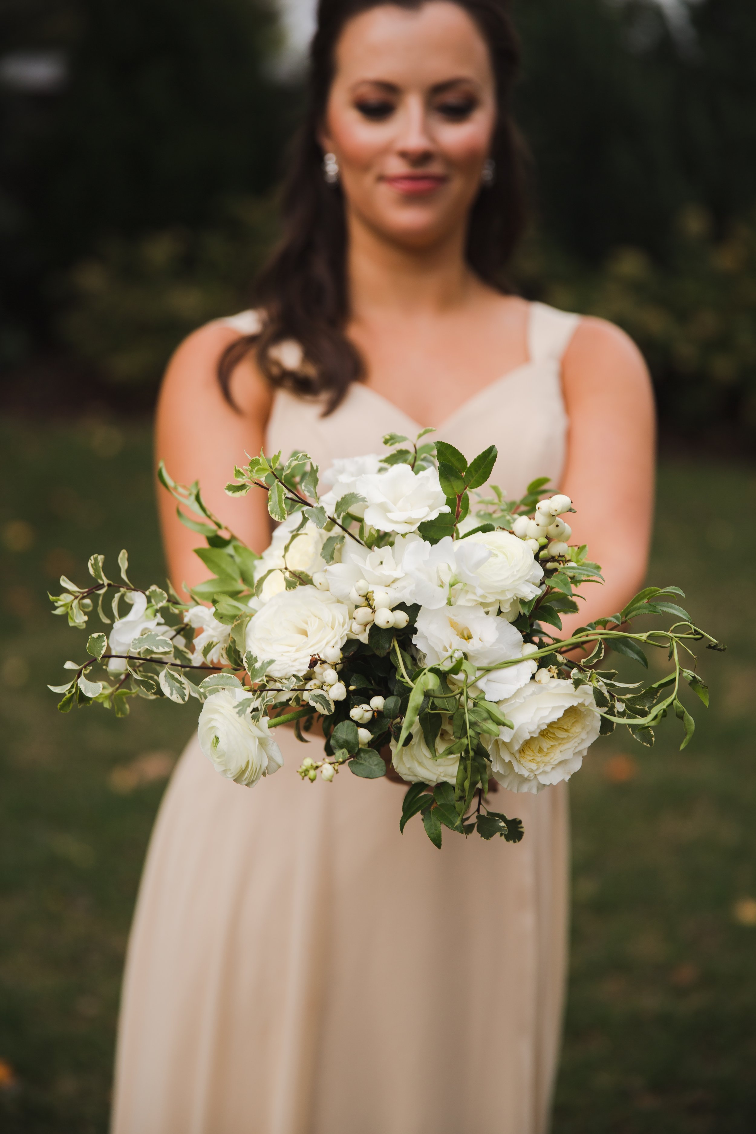 Bridal party florals for lush white and green wedding. Composed of petal-heavy roses, garden roses, ranunculus, sweet peas, berries, and greenery. Designed by Rosemary and Finch in Nashville, TN.