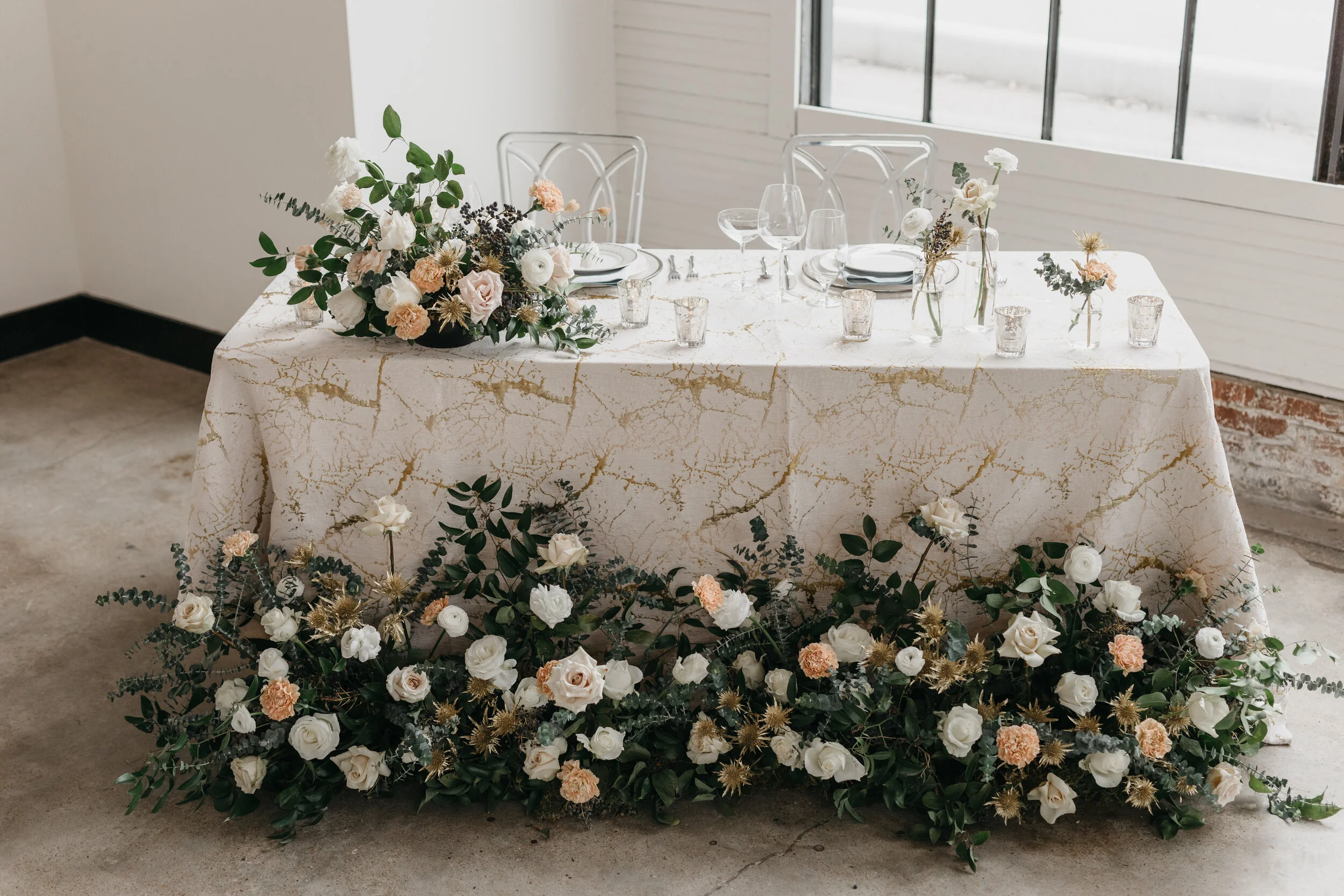 Wintery growing floor installation and tablescape featuring white and blush roses, touches of gold, baby eucalyptus and lush greenery. Nashville wedding florist Rosemary & Finch at OZARI.