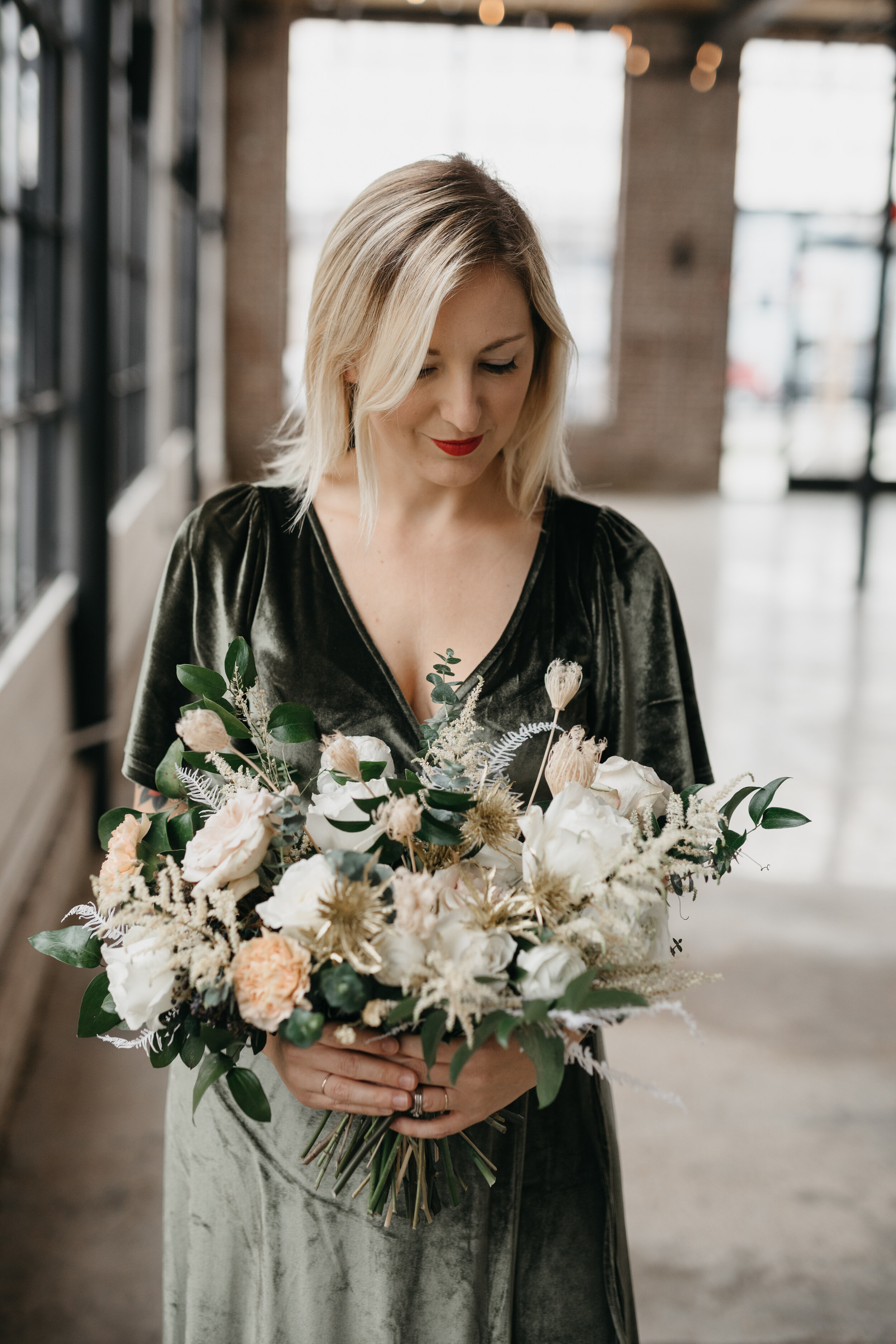 Wintery bouquet filled with fresh and dried florals, white roses, quicksand roses, astilbe, baby eucalyptus, lush greenery, and touches of gold. Nashville wedding florist Rosemary & Finch at OZARI.