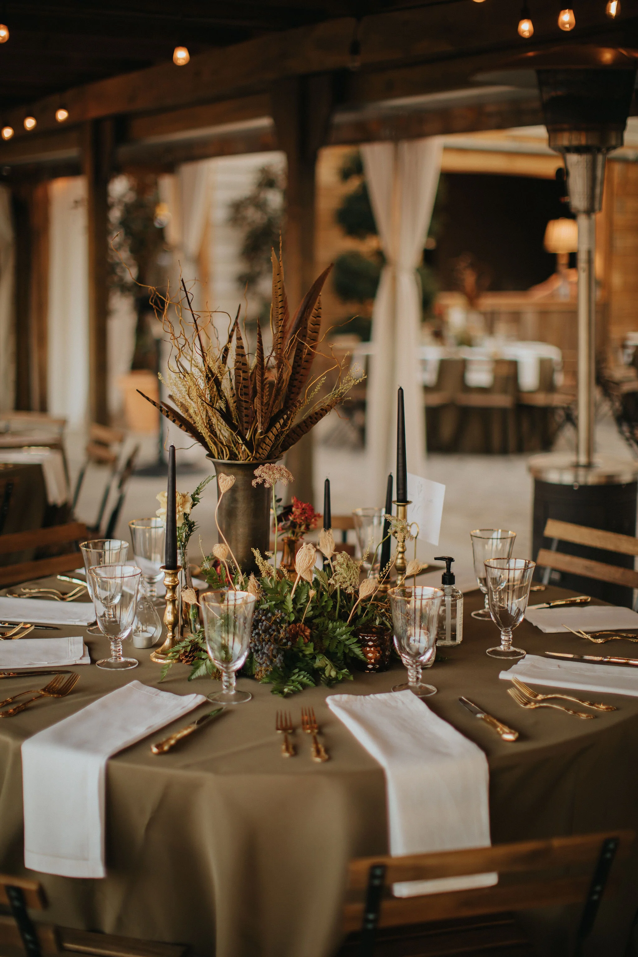 Earthy and romantic – this eclectic tablescape is crafted from pheasant feathers, brass candlesticks, and layered florals. Botanical cloches are filled with fern, moss, chocolate cosmos, and ranunculus. Designed by Nashville wedding floral designer,…