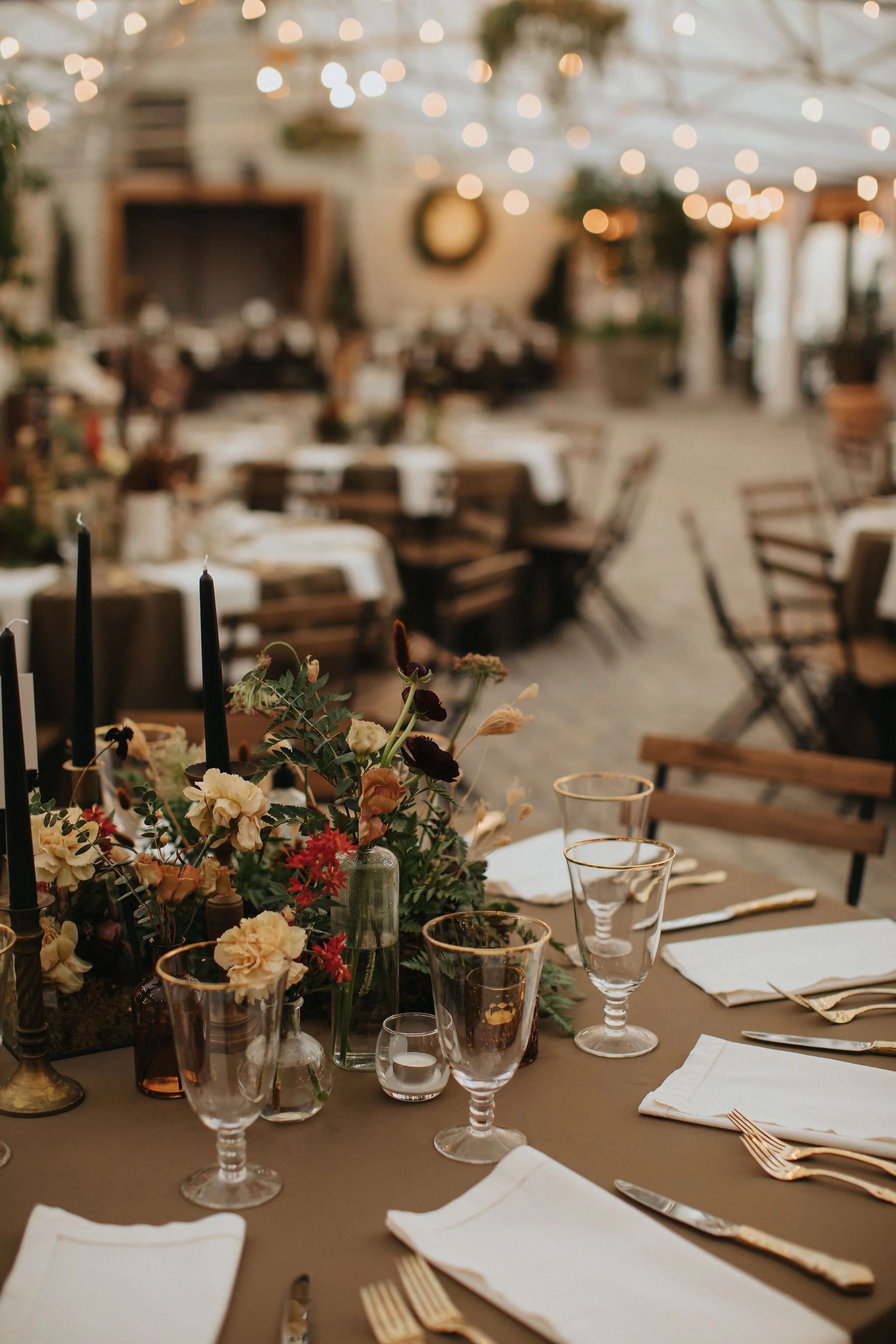 Earthy and romantic – this eclectic tablescape is crafted from pheasant feathers, brass candlesticks, and layered florals. Botanical cloches are filled with fern, moss, chocolate cosmos, and ranunculus. Designed by Nashville wedding floral designer,…