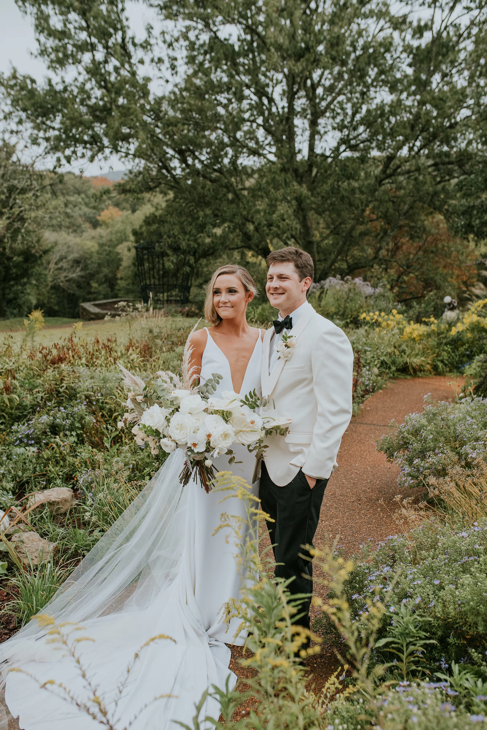Bohemian and modern yet classically elegant. This Bridal bouquet perfectly married boho elements of pampas grass, eucalyptus, and dried florals with topical stems of anthurium, orchid and ranunculus for a fresh take on white. Designed by Nashville w…