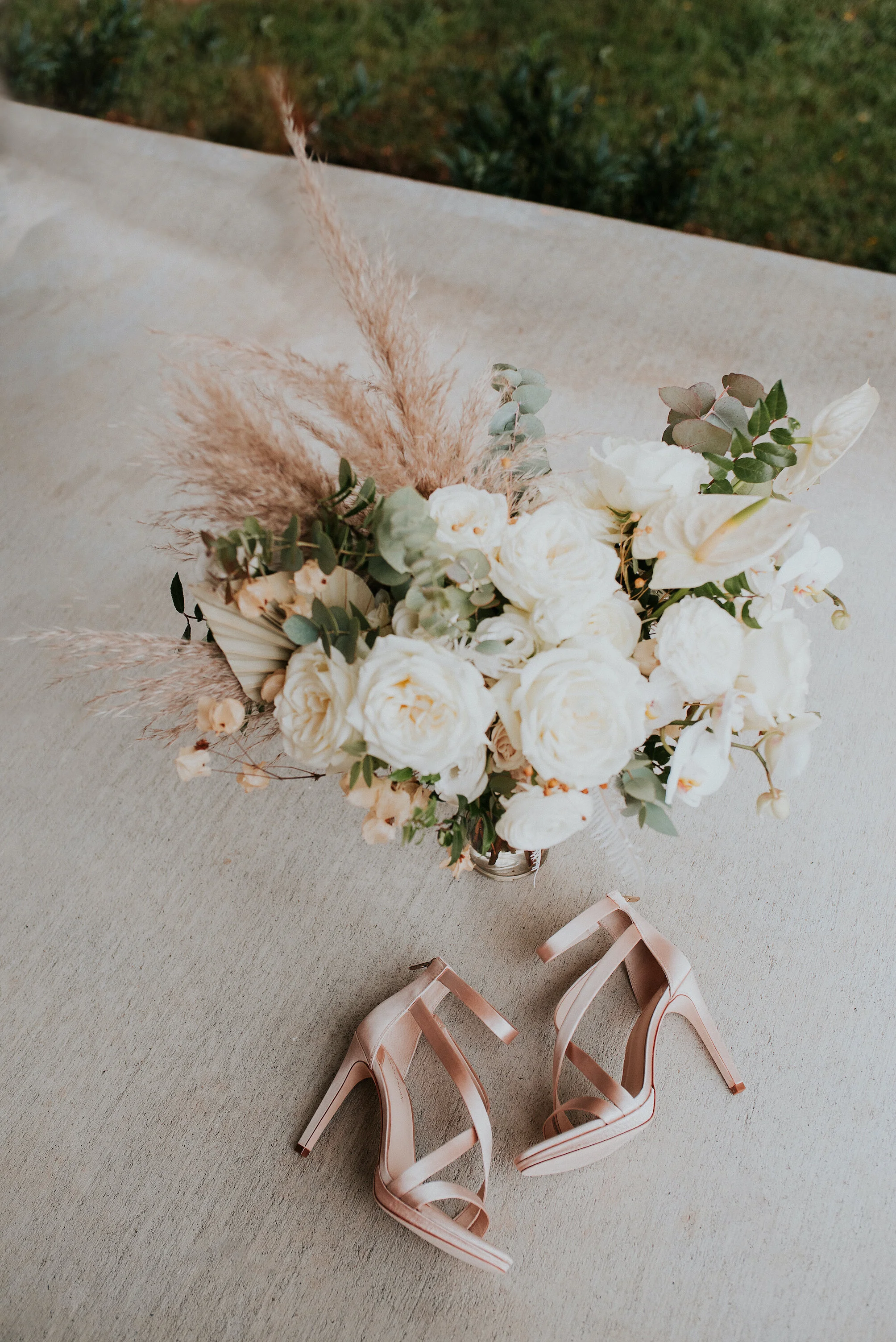 Bohemian and modern yet classically elegant. This Bridal bouquet perfectly married boho elements of pampas grass, eucalyptus, and dried florals with topical stems of anthurium, orchid and ranunculus for a fresh take on white. Designed by Nashville w…
