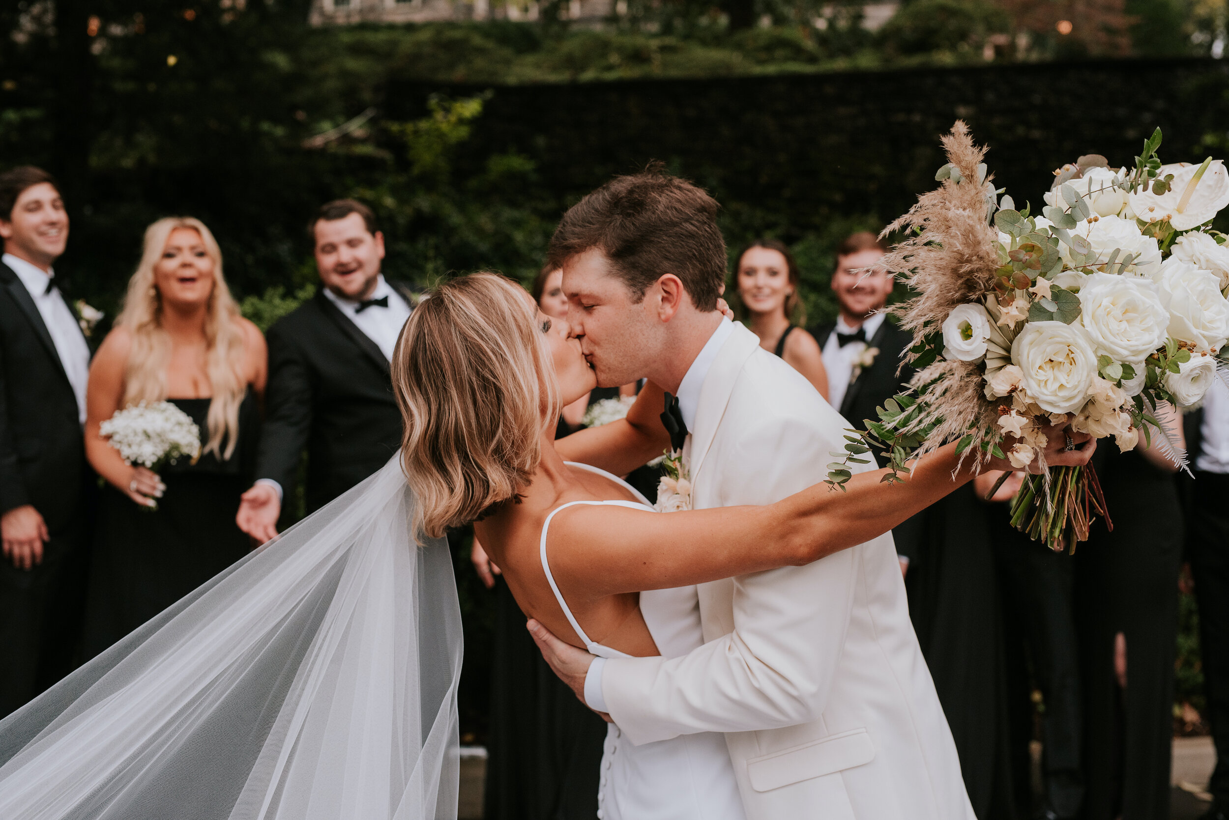 Bohemian and modern yet classically elegant. This Bridal bouquet perfectly married boho elements of pampas grass, eucalyptus, and dried florals with topical stems of anthurium, orchid and ranunculus for a fresh take on white. Designed by Nashville w…