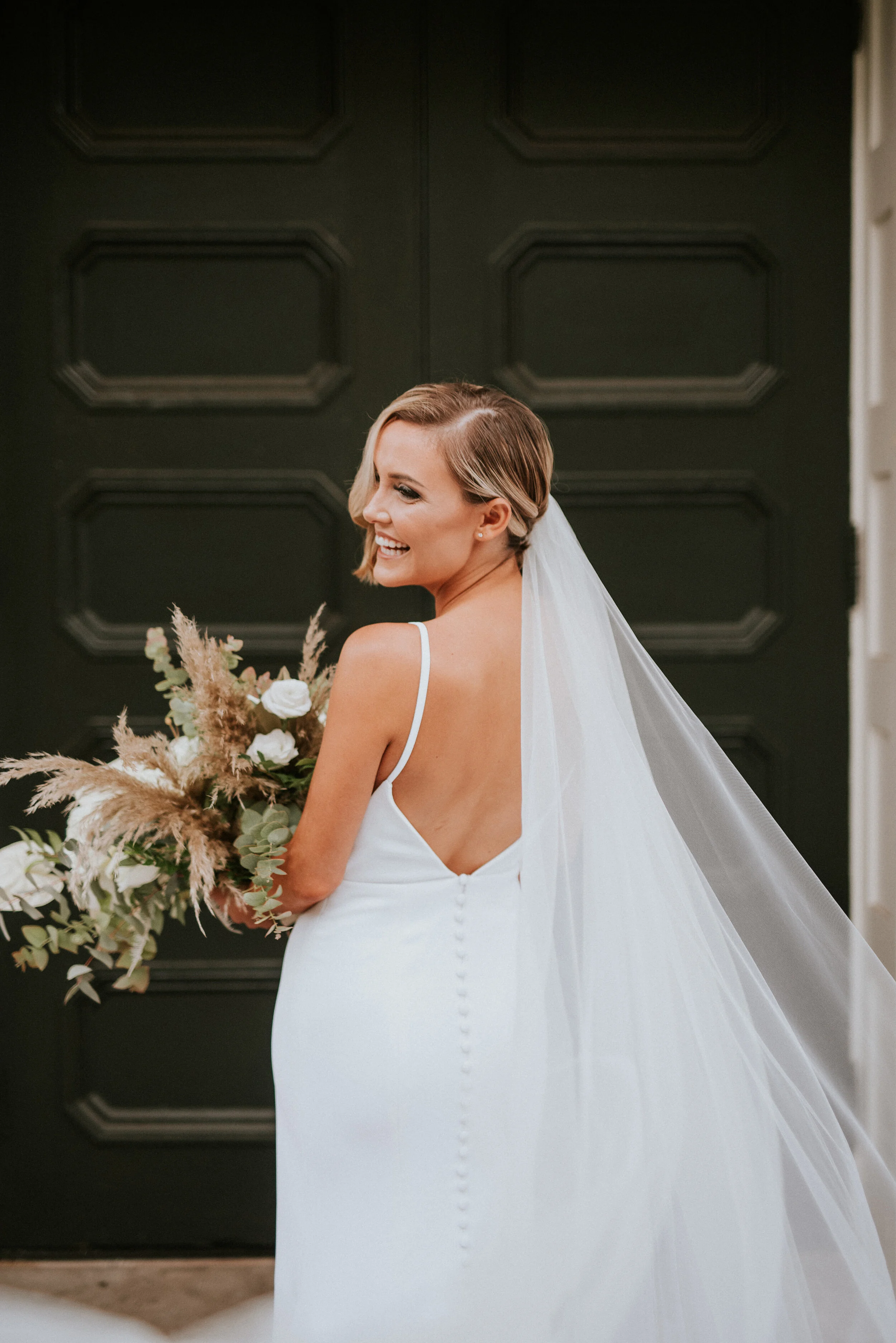 Bohemian and modern yet classically elegant. This Bridal bouquet perfectly married boho elements of pampas grass, eucalyptus, and dried florals with topical stems of anthurium, orchid and ranunculus for a fresh take on white. Designed by Nashville w…