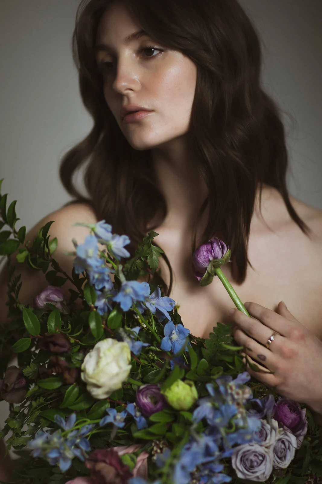 Greek inspired maternity shoot with a wearable floral garland filled with blue delphinium, lavender spray roses, plum ranunculus, blush and fuchsia roses. Designed by wedding florist Rosemary & Finch in Nashville.