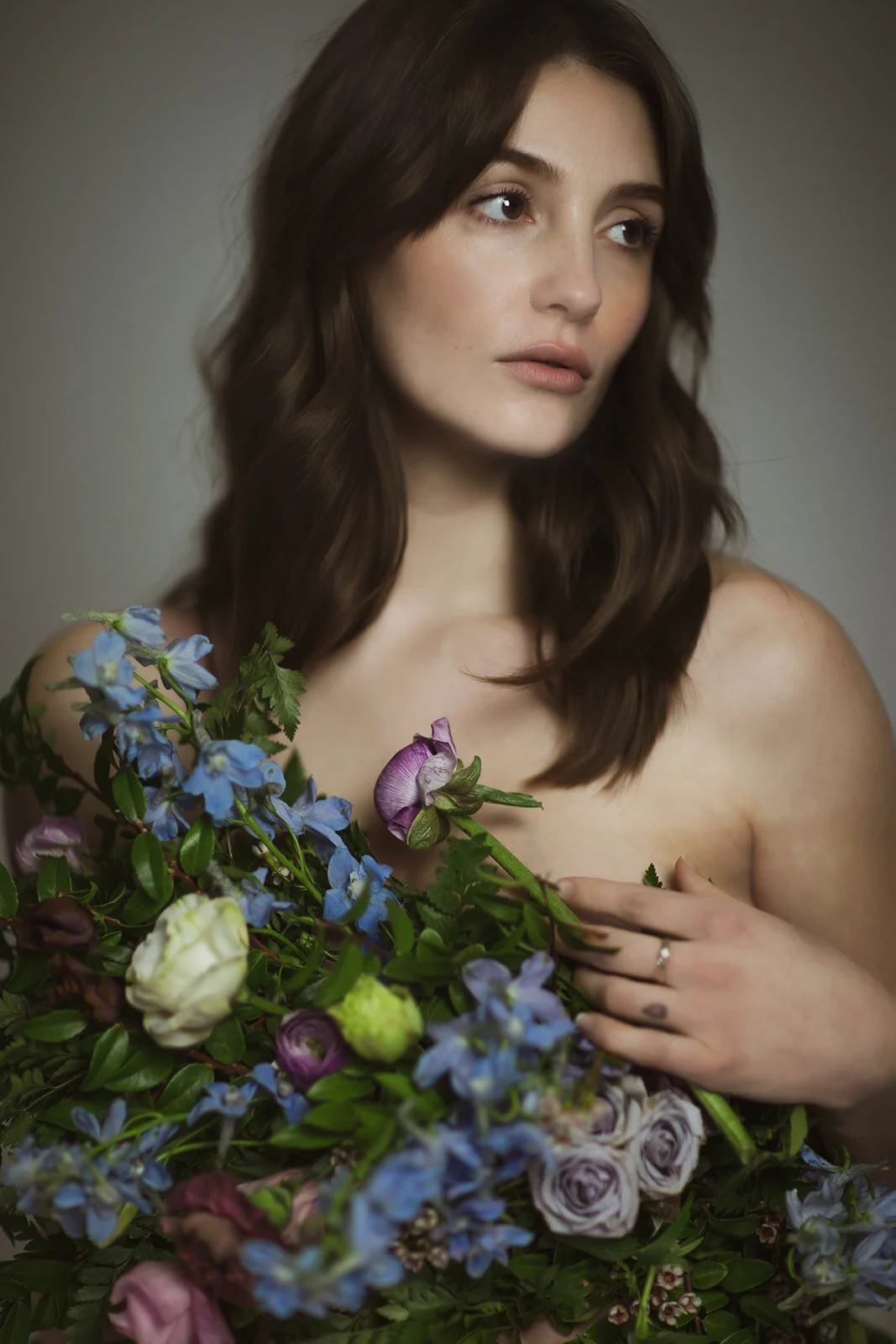 Greek inspired maternity shoot with a wearable floral garland filled with blue delphinium, lavender spray roses, plum ranunculus, blush and fuchsia roses. Designed by wedding florist Rosemary & Finch in Nashville.