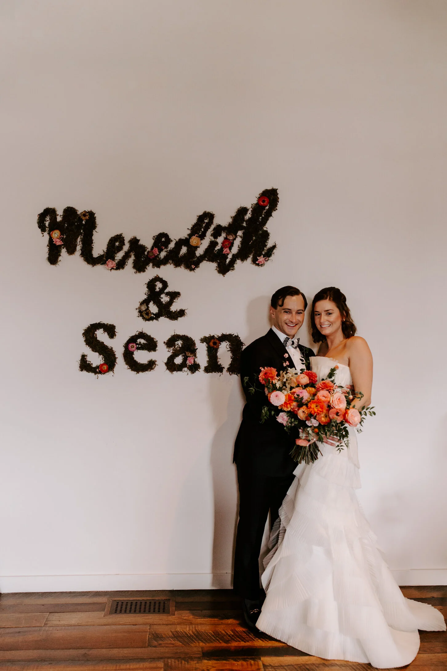 The happiest late summer bridal bouquet overflowing with blooms. This bouquet is filled with coral zinnias, fuchsia and blush dahlias, tangerine ranunculus, petal-heavy roses, pink snowberry, and touches of smilax vine. Designed by Nashville wedding…