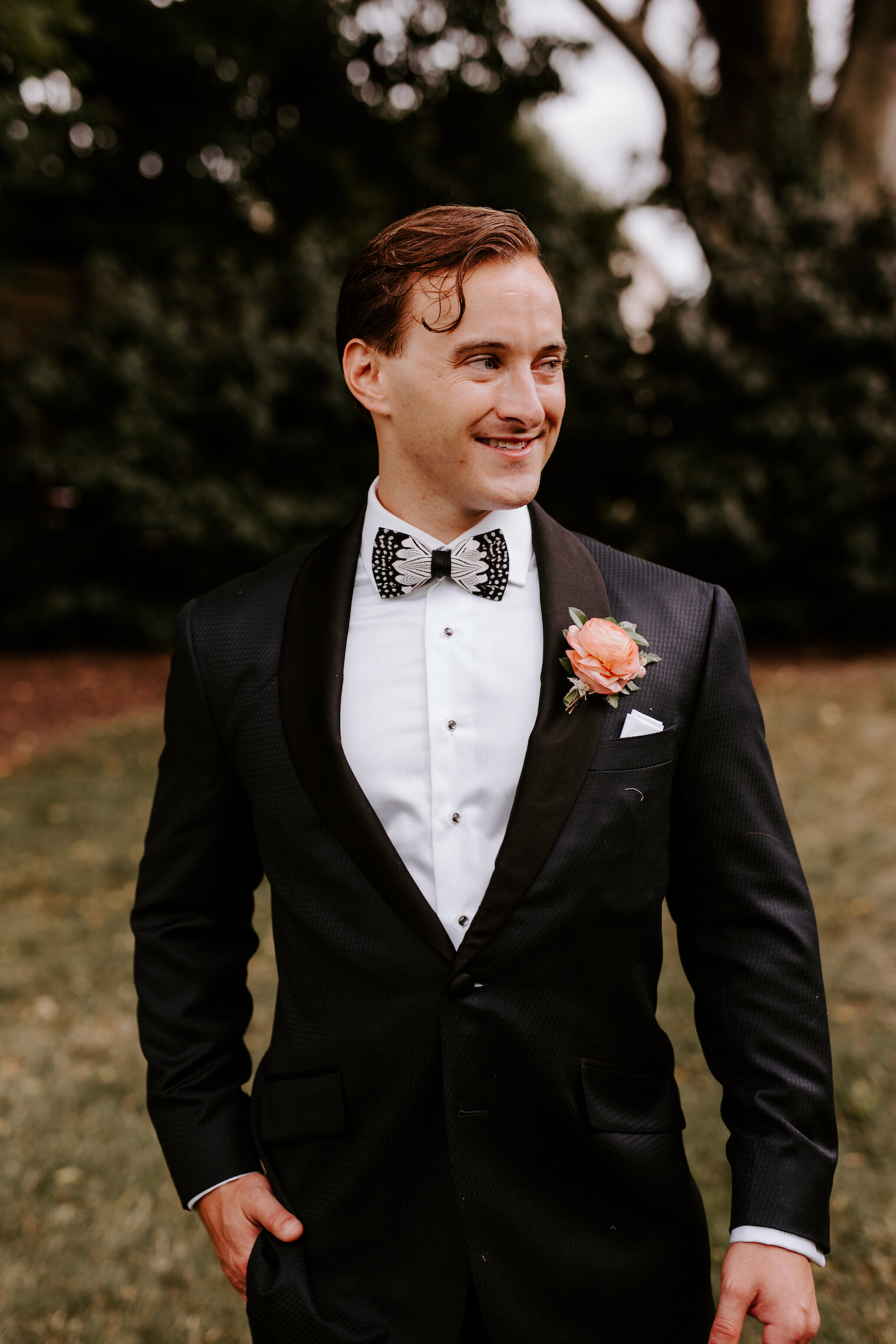 A delicate and bright boutonniere featuring peach ranunculus, pink snowberry, and huckleberry. Designed by Nashville wedding floral designer, Rosemary & Finch at The Cordelle.
