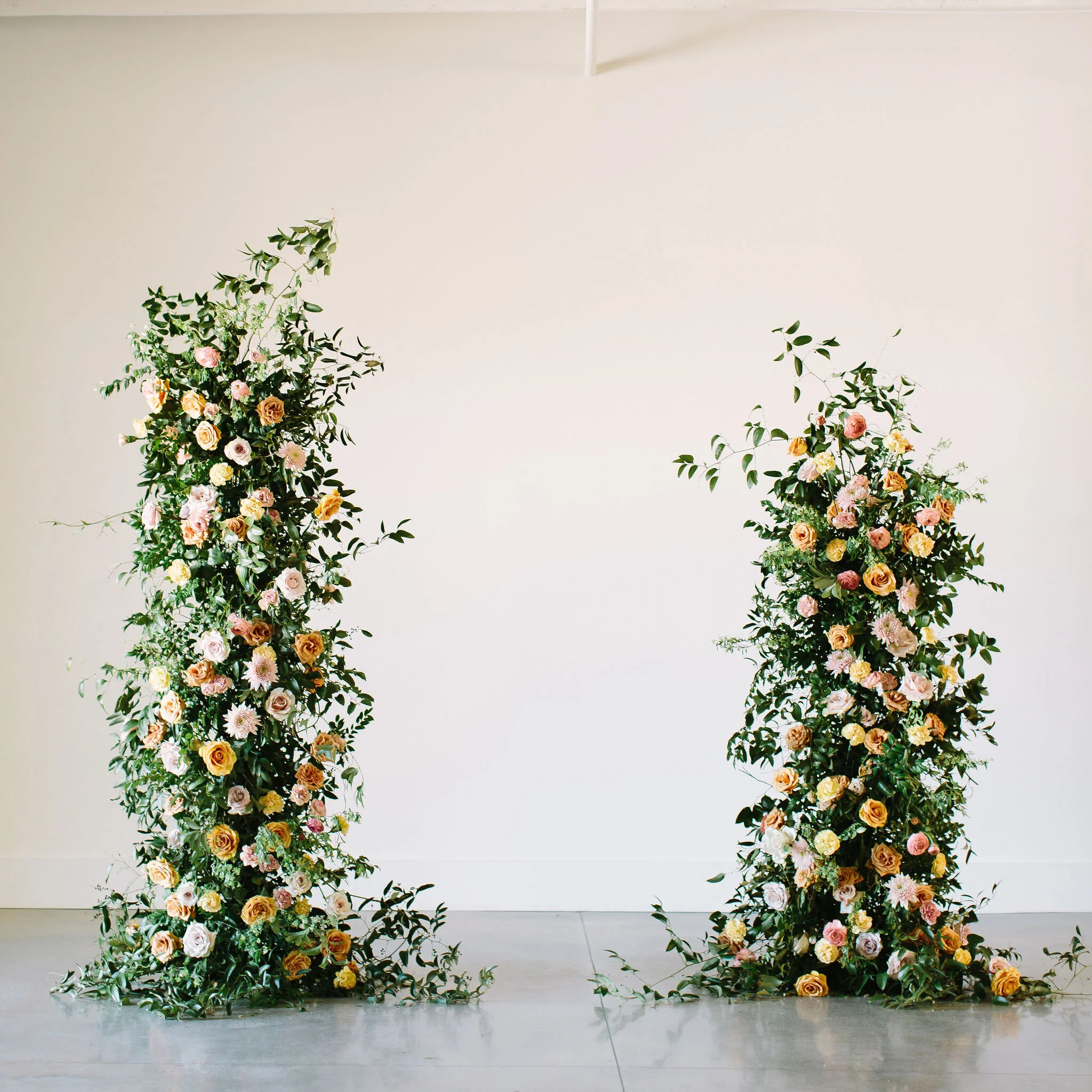 An intimate installation intensive at The Saint Elle in Nashville. Students learned how to create and build 3 different kinds of installations. This elegant broken arch is comprised of golden combo roses, pink mums, nude carnations, blush ranunculus…